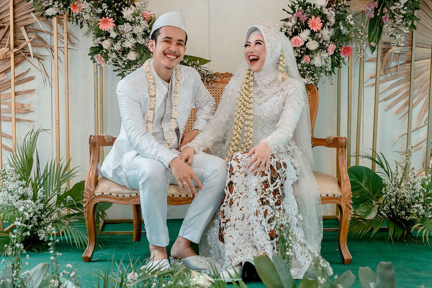Traditional Indonesian wedding ceremony setup with floral decorations and elegant seating.