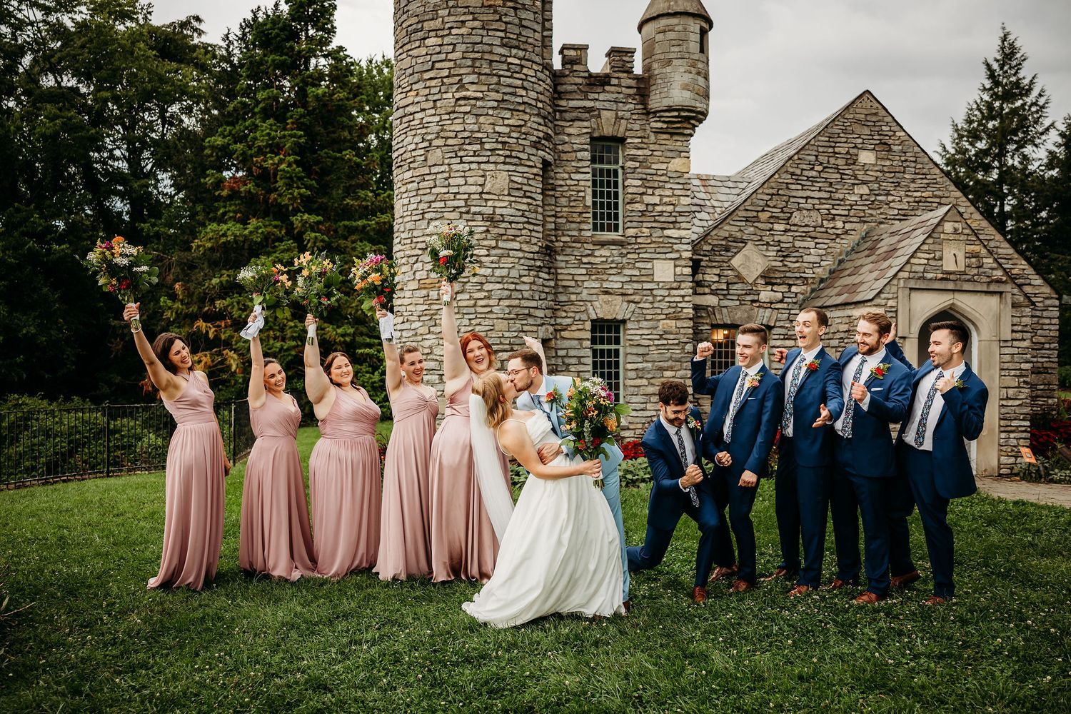 Couple kissing in front of bridal party at Yew Dell Gardens