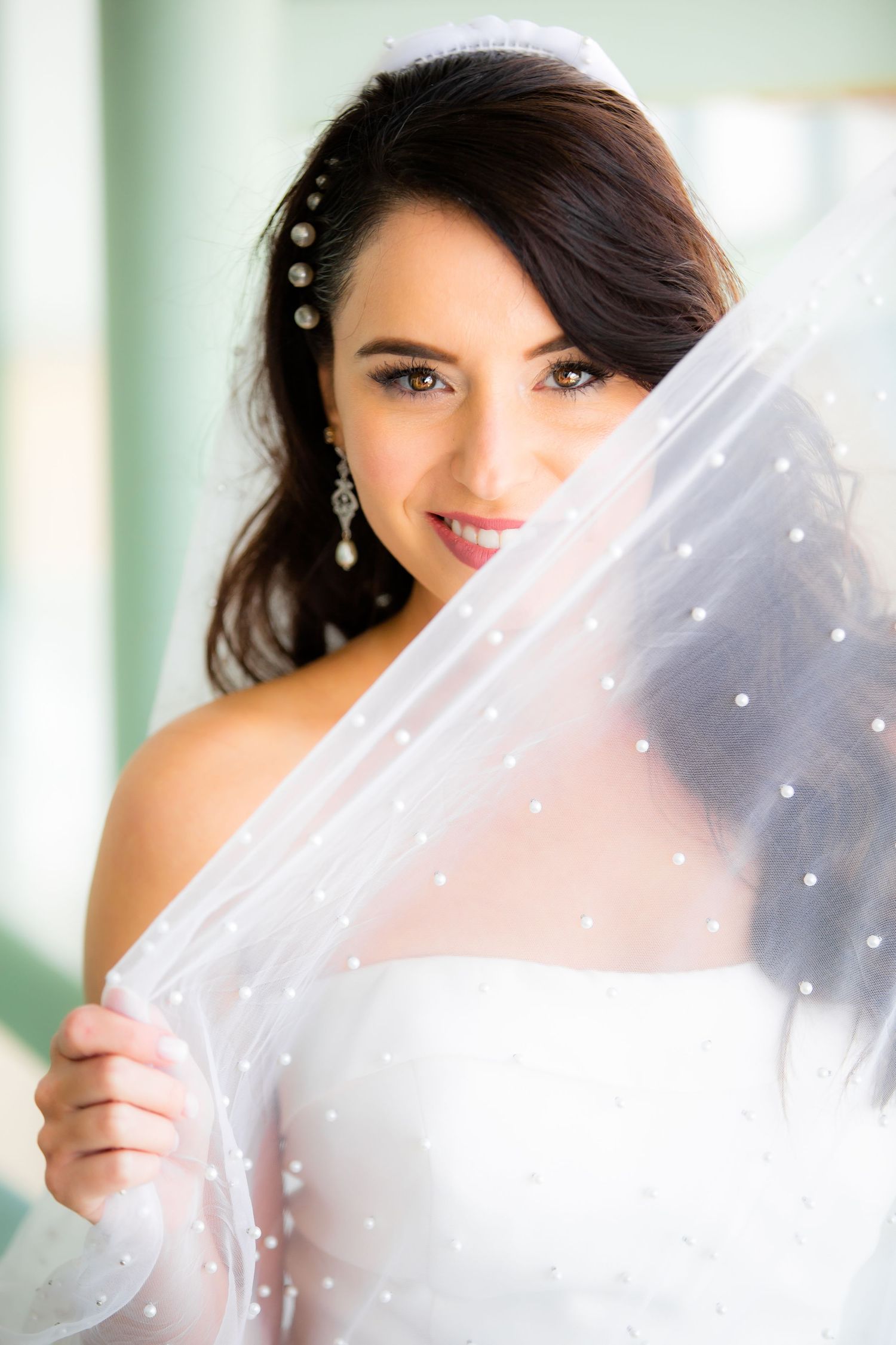 Romantic bridal portrait featuring delicate veil details and pearl accents.
