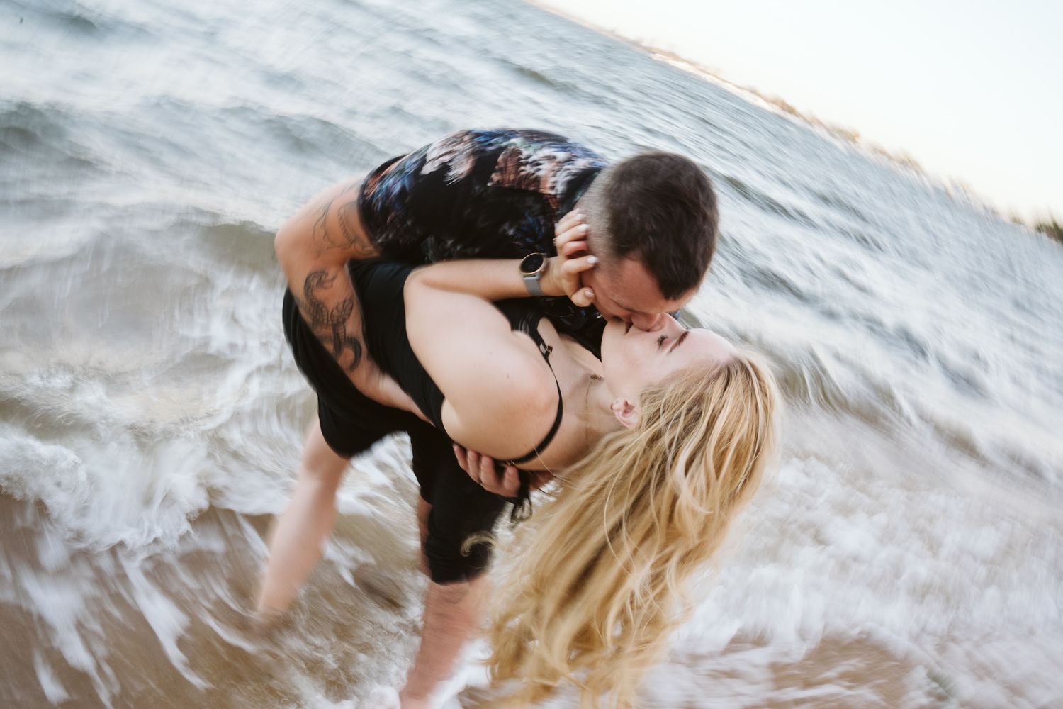 Couple kissing in the ocean waves at the beach