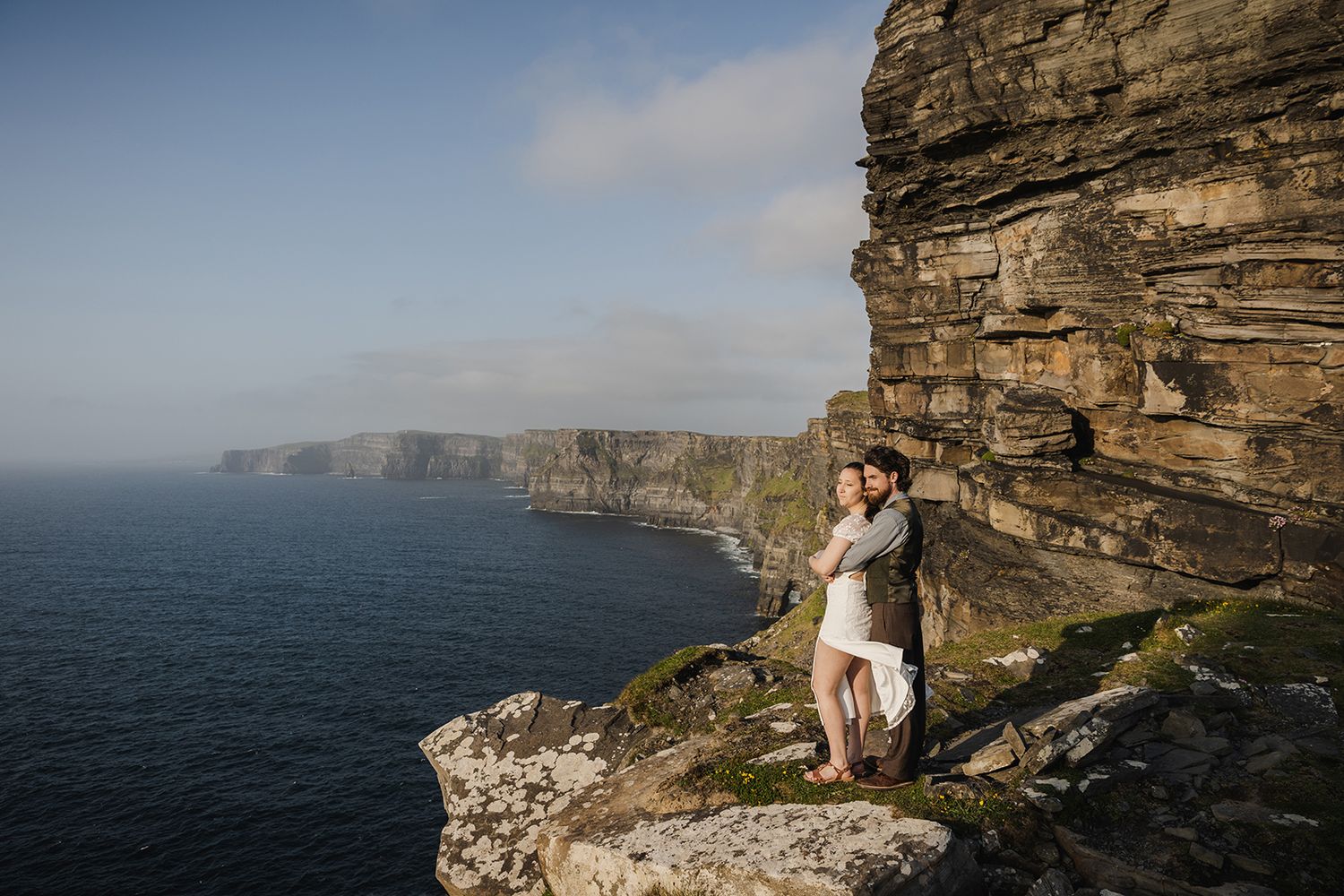 Adventurous couple eloping at Hags Head during golden hour ceremony surrounded by Irish coastal landscape
