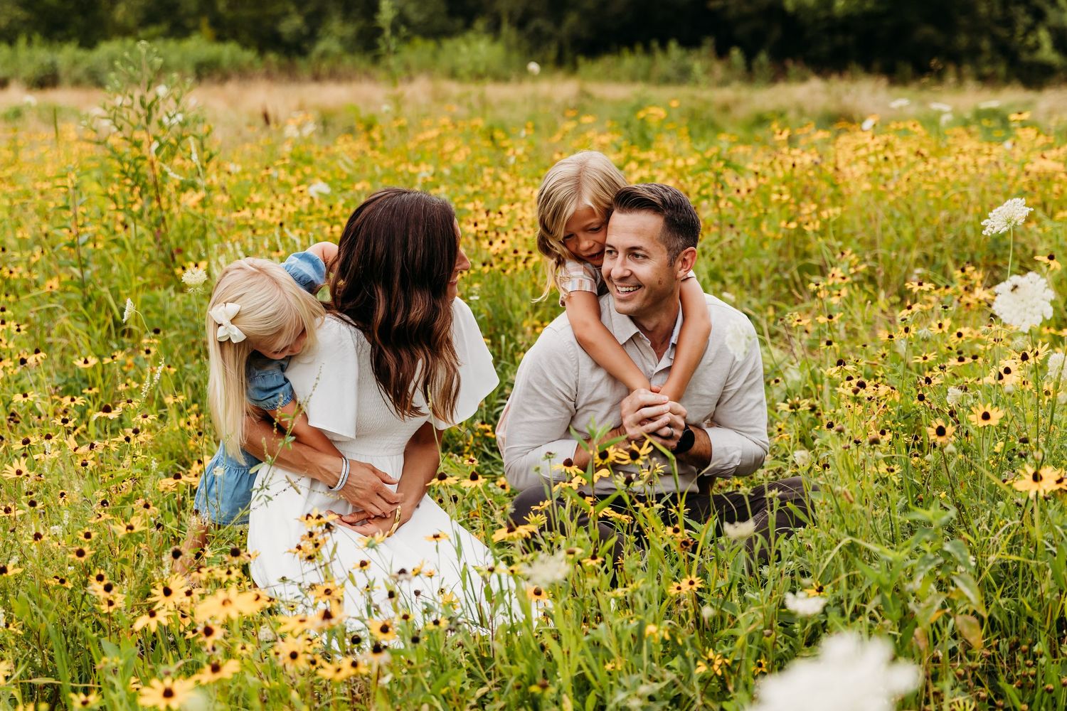 A couple lying in a vibrant wildflower meadow surrounded by yellow blooms on a sunny day.