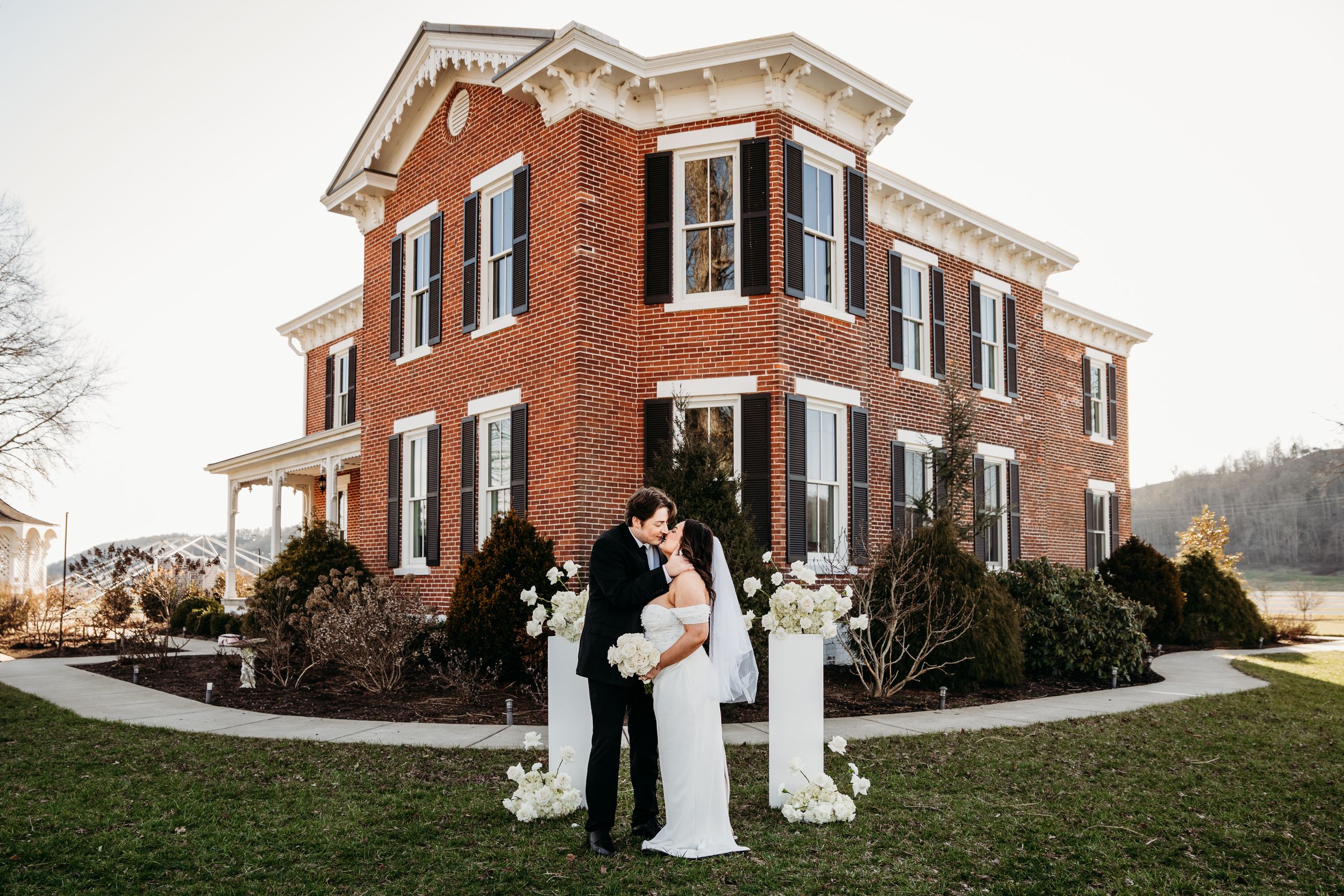 Bride and groom kiss outside of the Historic Woodlawn Mansion