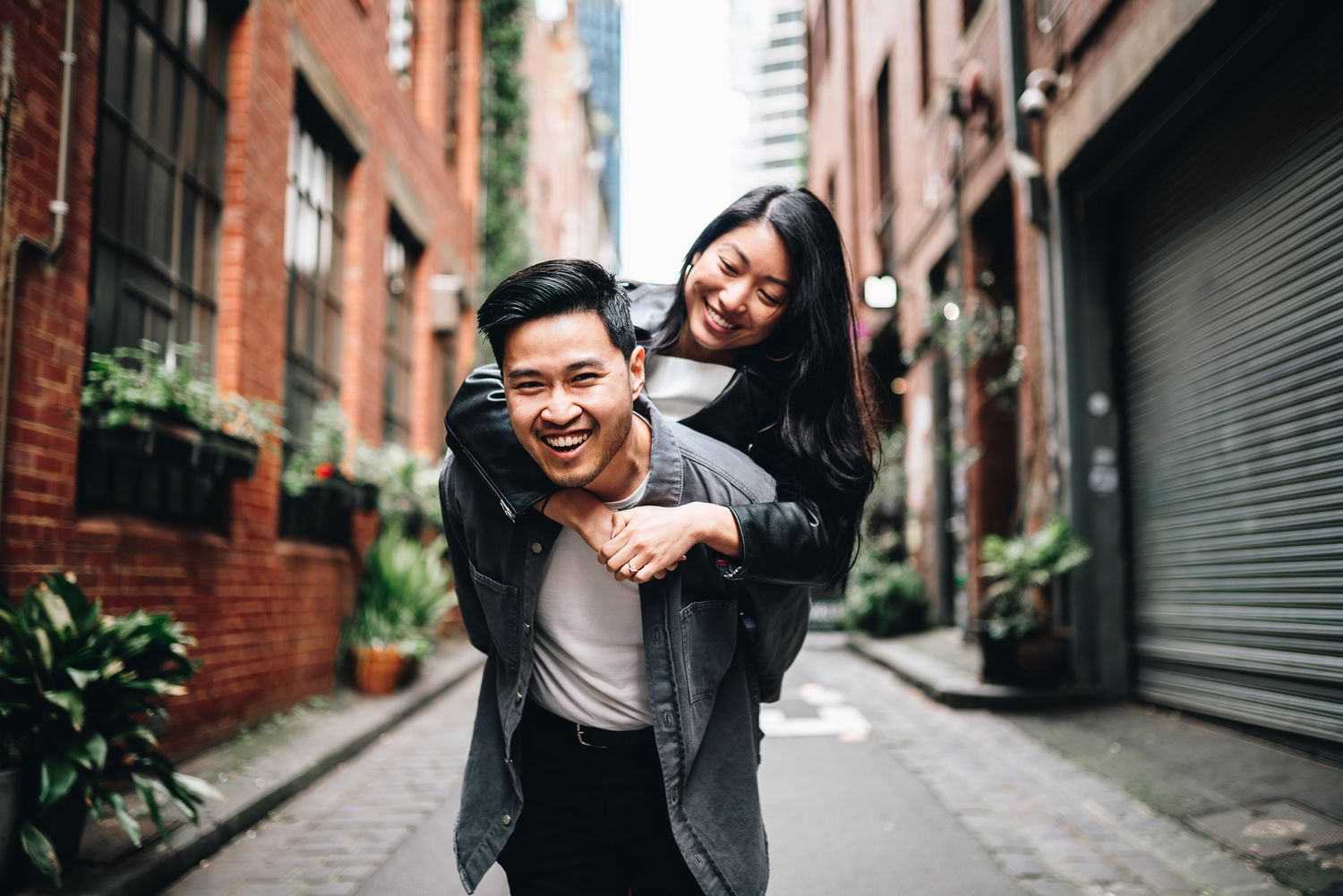 Melbourne photographer Pei A Photography capturing a casual couple on a piggyback ride for their engagement photos in the CBD