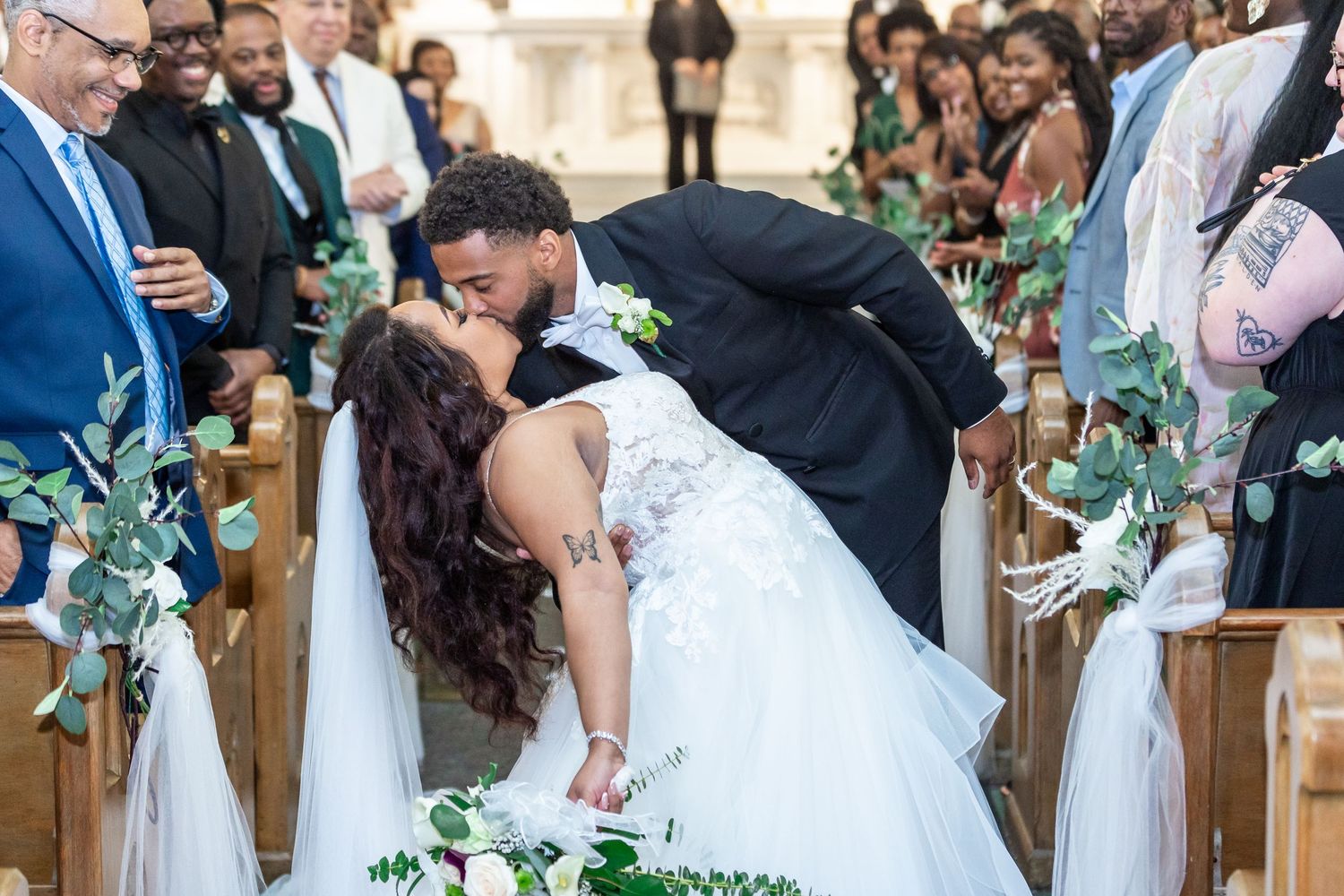 Palm Beach wedding photographers captured the groom dipping his bride in the center of the aisle for a kiss after the wedding ceremony.