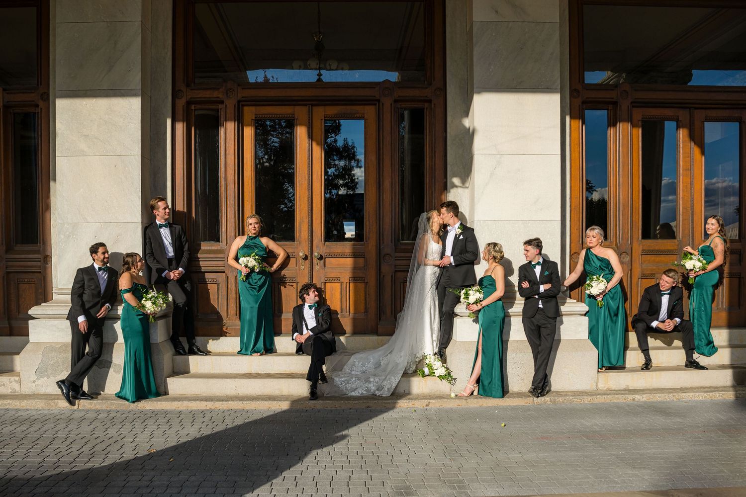 Elegant wedding flat lay with pearl-adorned heels, calla lily, diamond ring, and floral invitation cards.