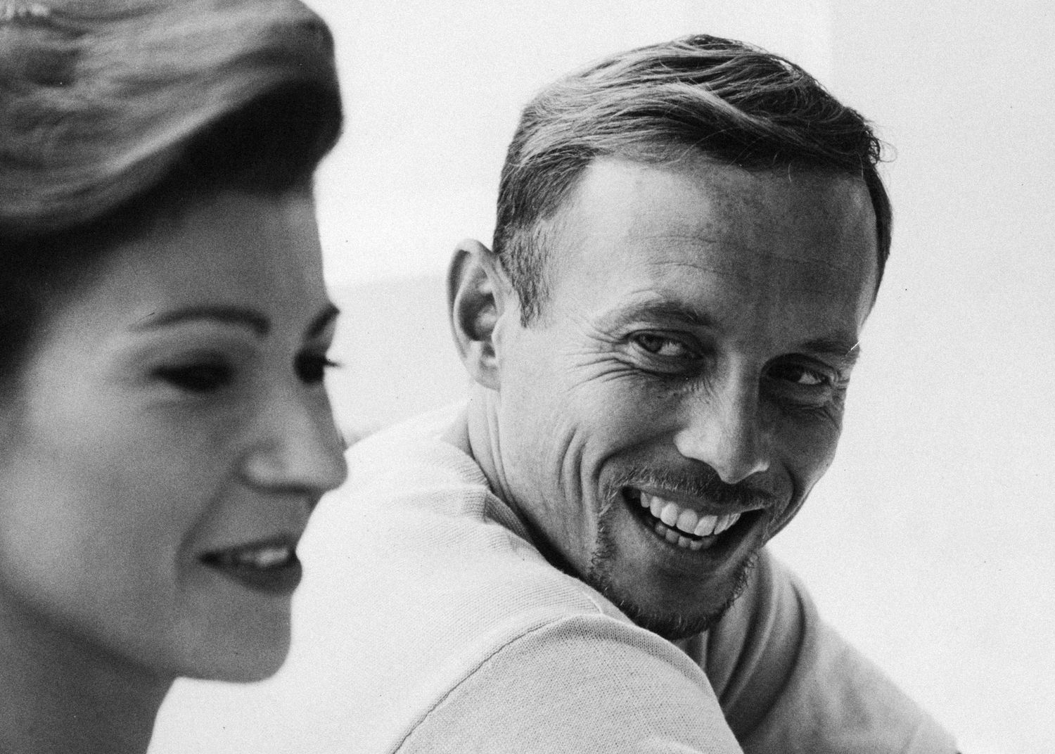 Black and white photo of a smiling man and woman in a candid, close-up portrait shot.