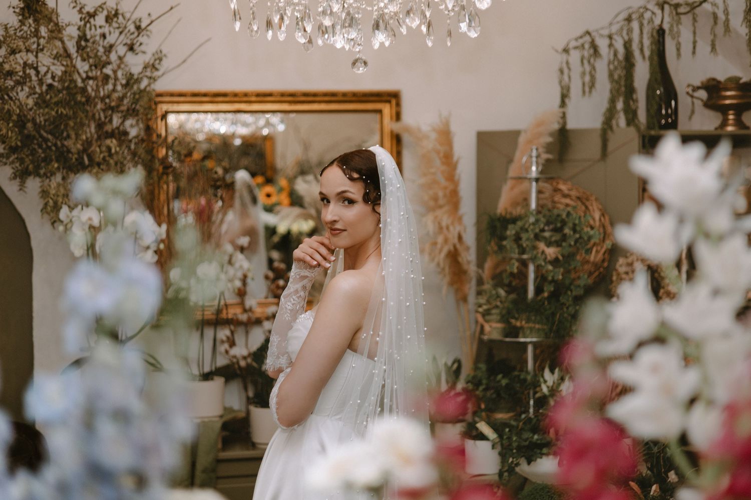 Portrét očarujúcej nevesty v elegantnom interiéri s kvetmi a zrkadlom. Umelecký svadobný fotograf pre Žilinský kraj.