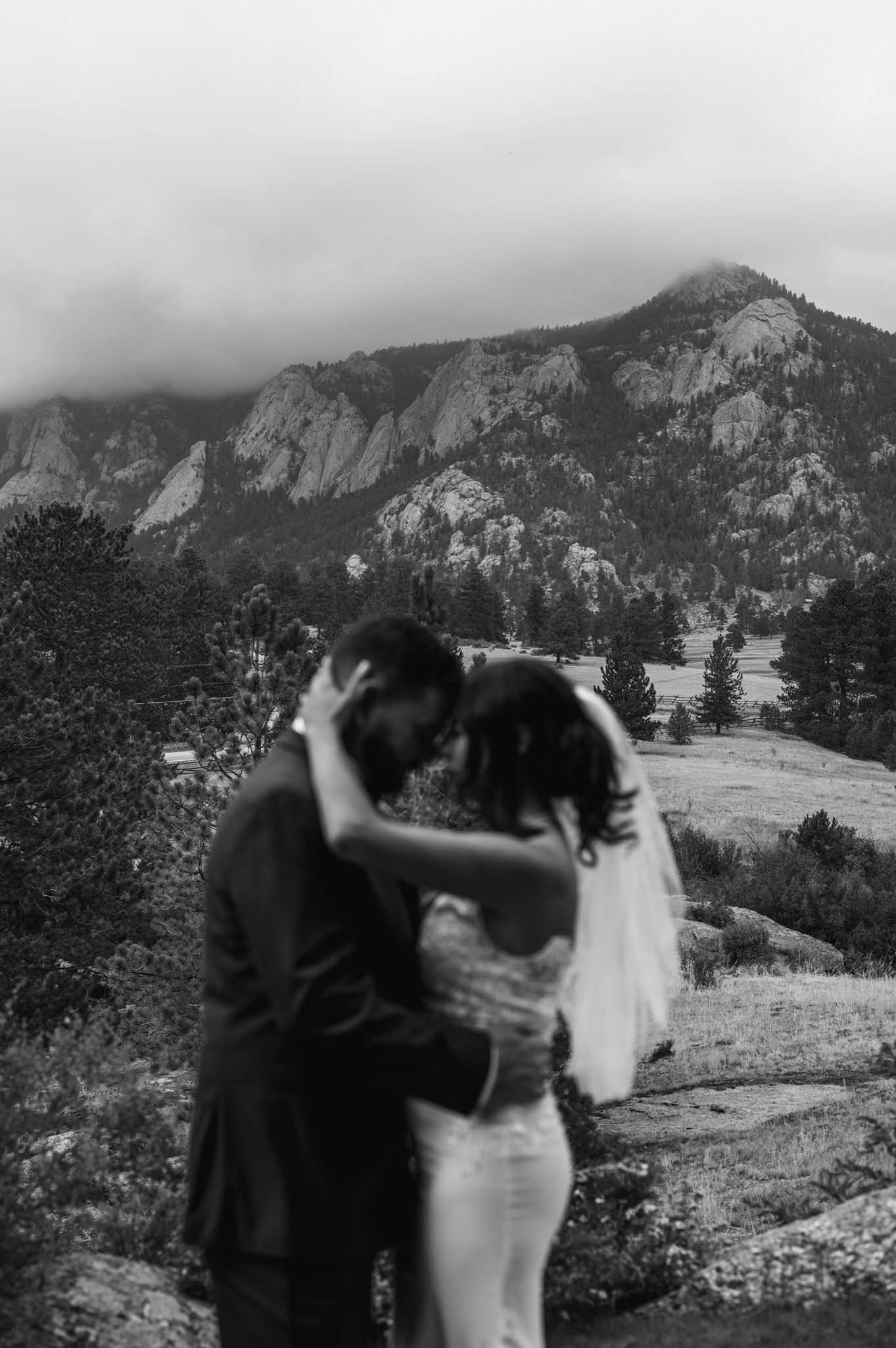 A romantic black and white wedding photoshoot in front of majestic mountain peaks and rolling hills.