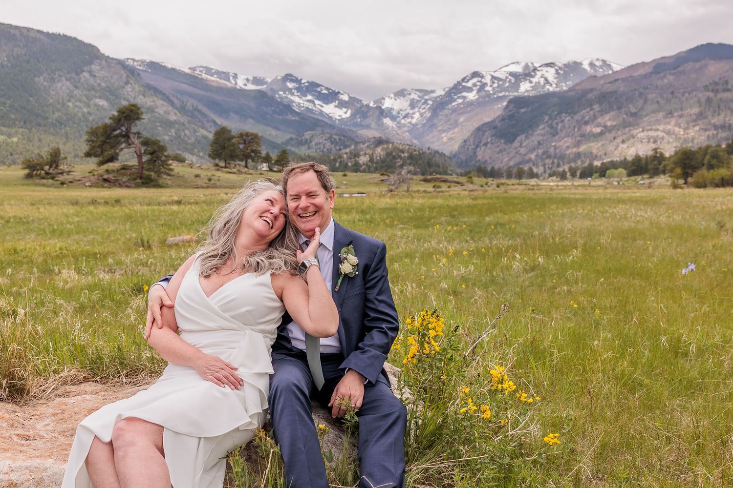 Couple eloping in Rocky Mountain National Park with scenic mountain backdrop and golden meadow, celebrating an intimate, adventurous wedding