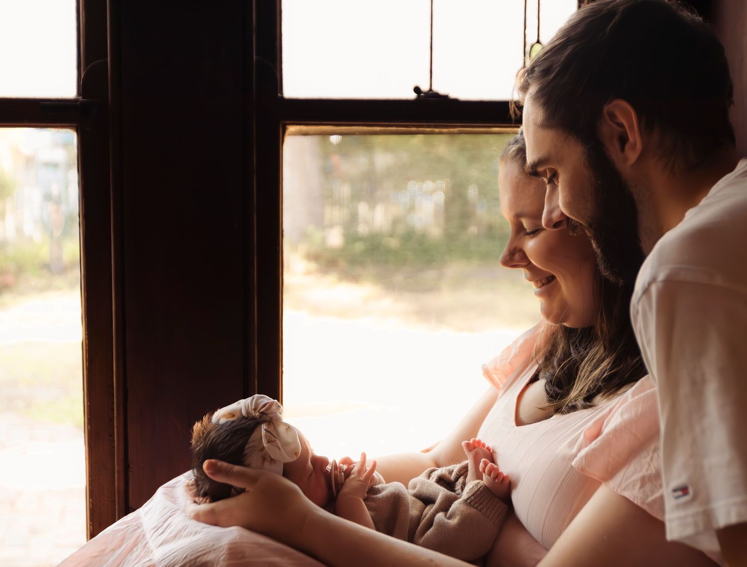 Intimate indoor photo session with natural window lighting.