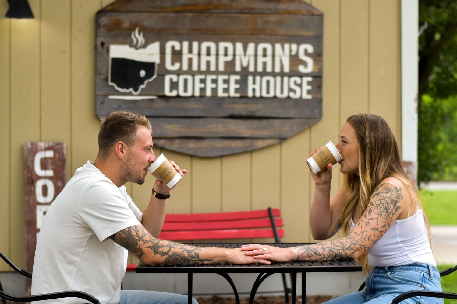 Two people enjoy coffee and conversation at an outdoor table near Chapman's Coffee House patio.
