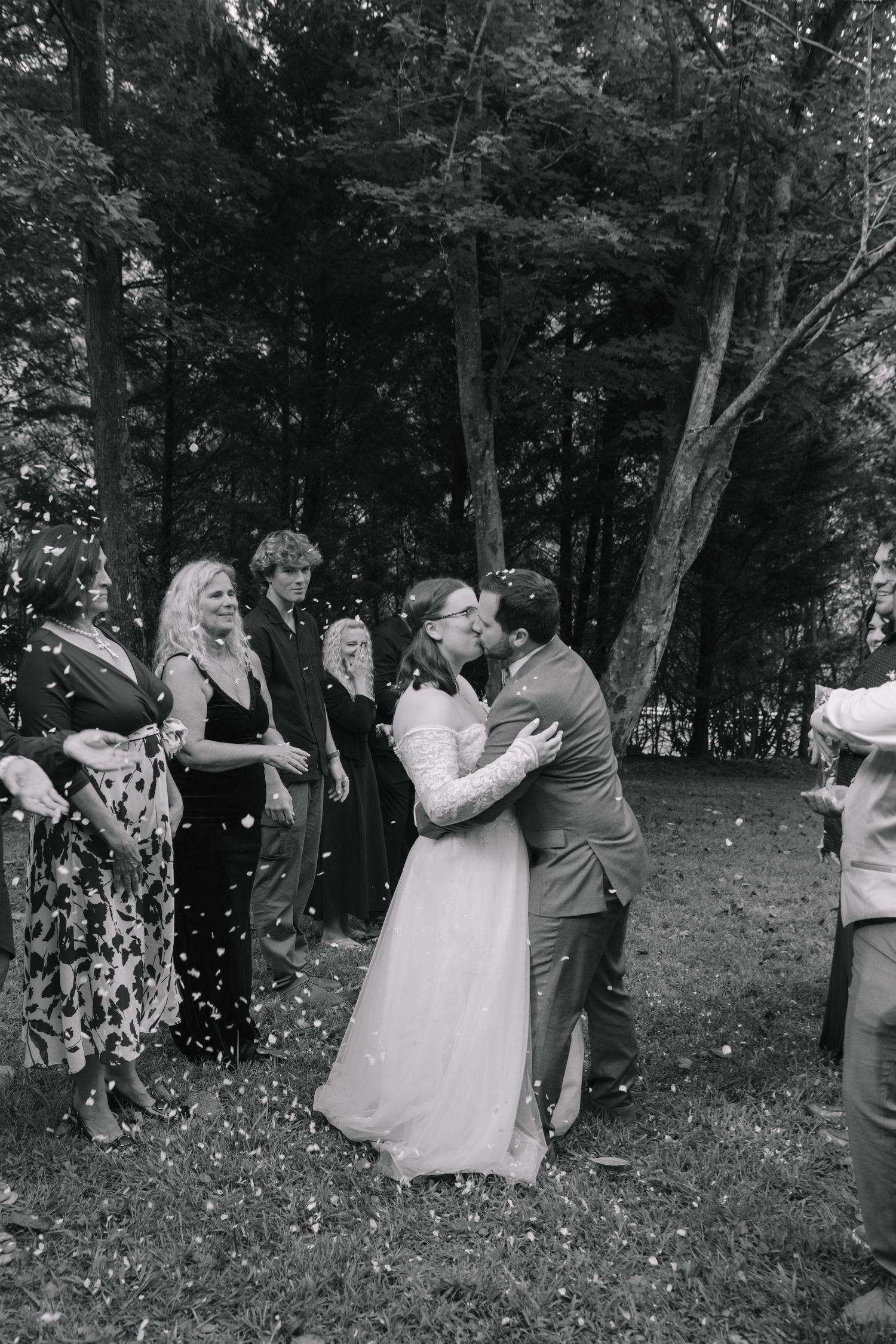 Black and white photo series of couples dancing together in a wooded outdoor setting during a celebration.
