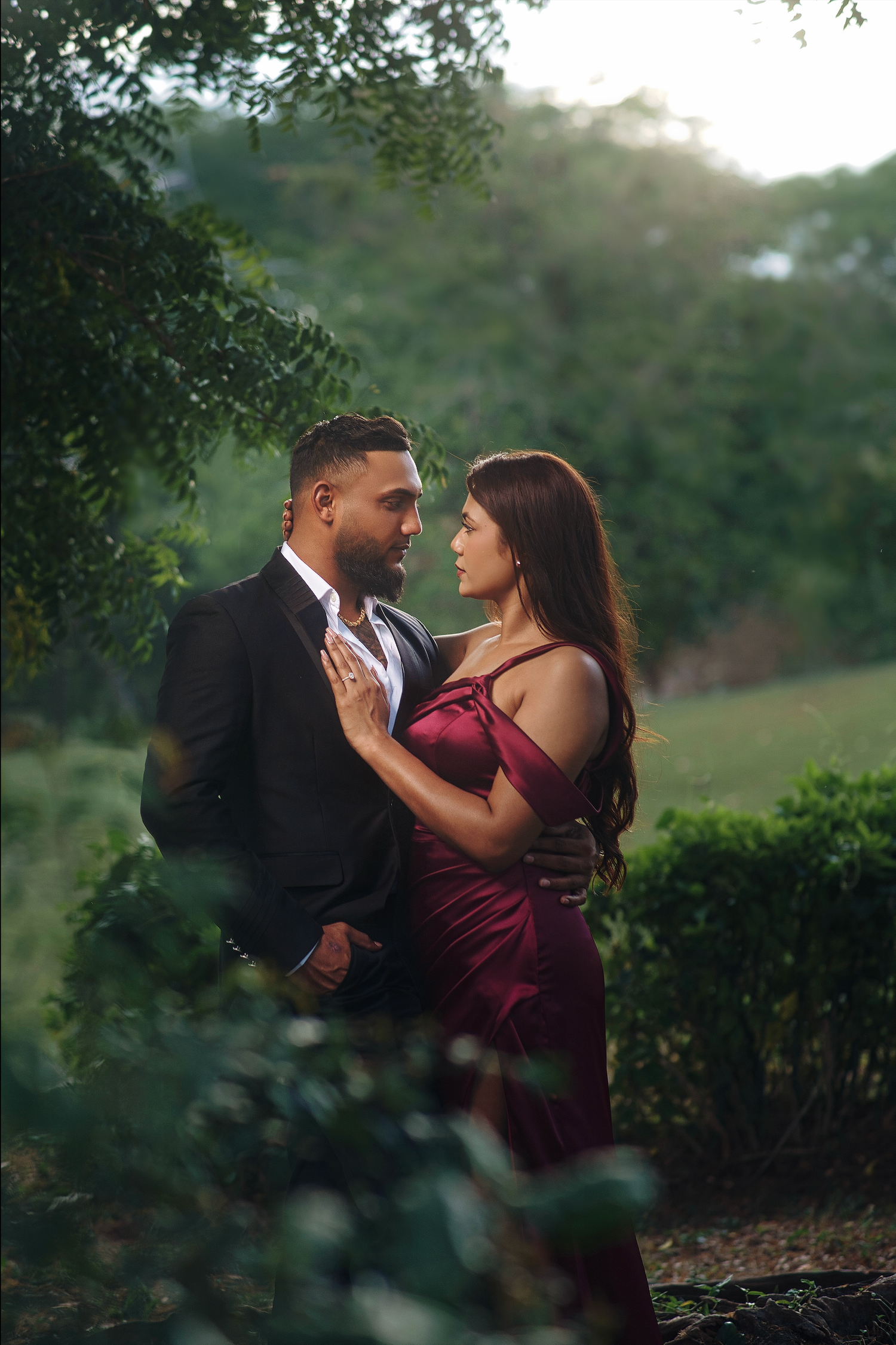 Traditional South Asian wedding couple in ornate red and cream attire share an intimate moment during their ceremony.