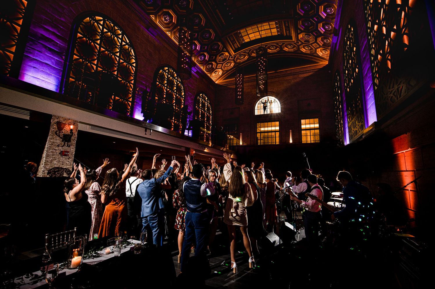 Wedding couple at a Union Trust wedding with dramatic purple lighting and ornate arched ceiling with stained glass windows.