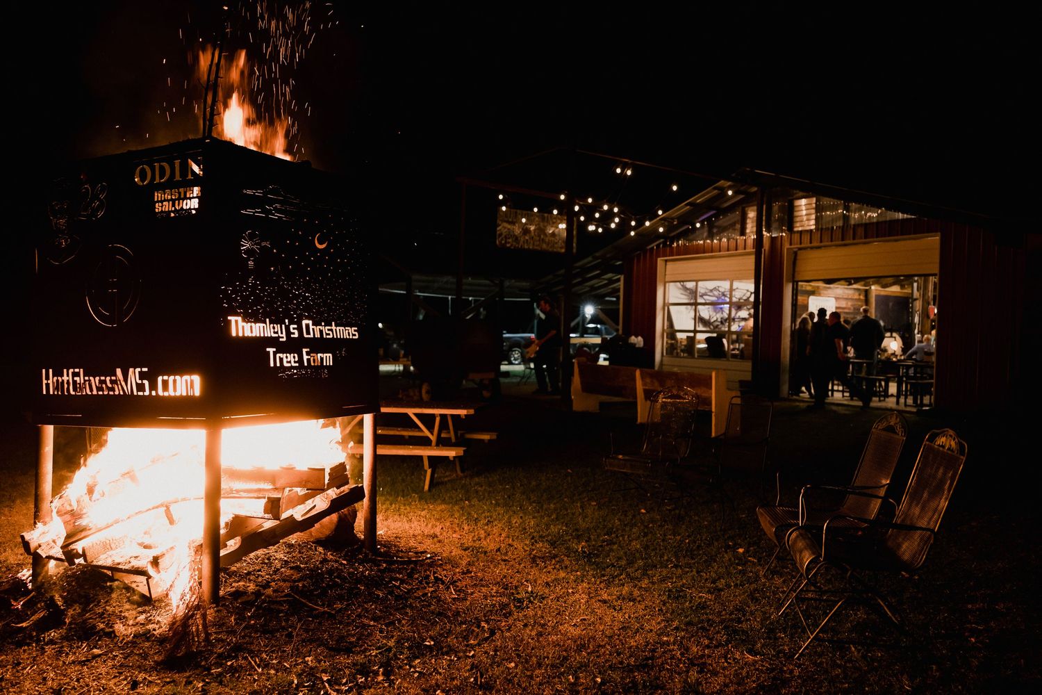 Panoramic nighttime view showing scattered lights and fires across a dark landscape.