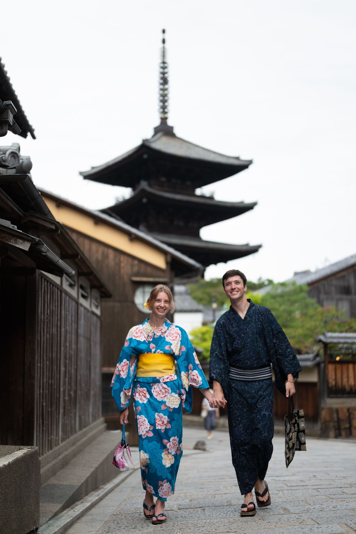 Couple wearing traditional Japanese kimono walking near Yasaka Pagoda in Kyoto, Japan.