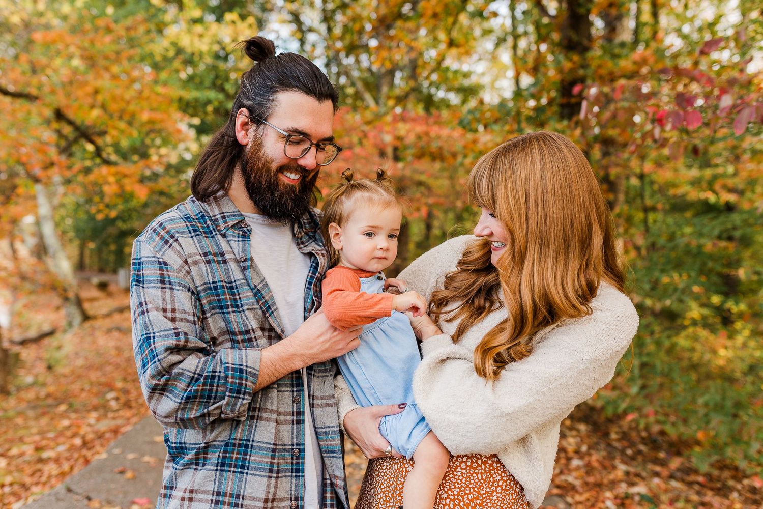 A candid autumn moment in a wooded setting with fall colors in the background.