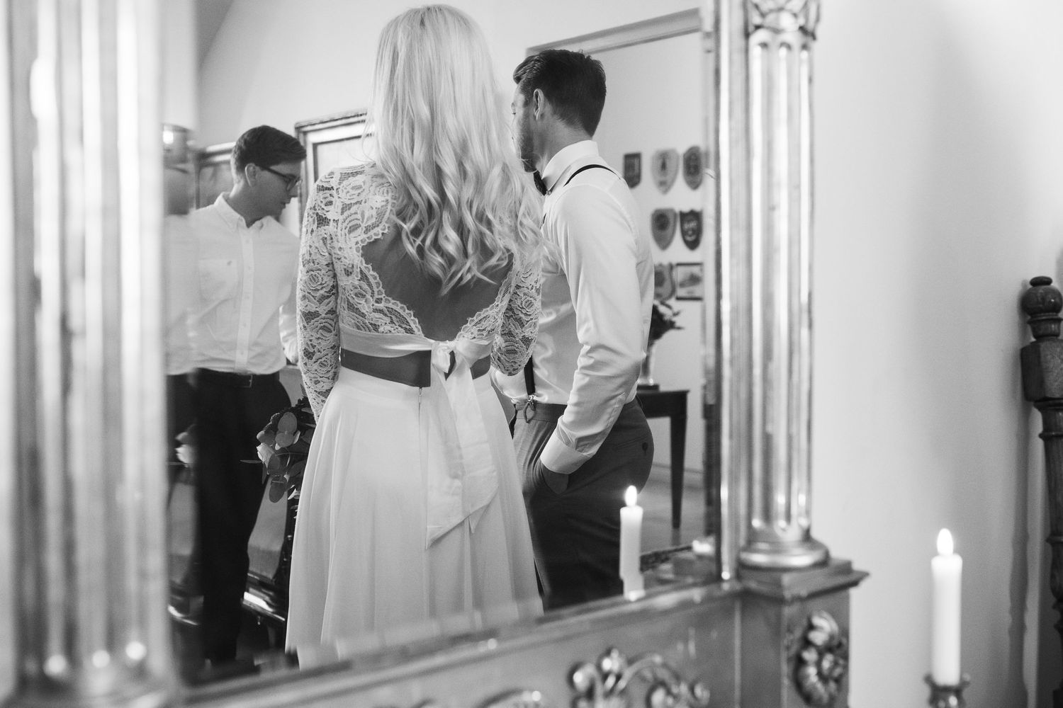 A black and white reflection of a wedding couple getting ready in an elegant mirror.