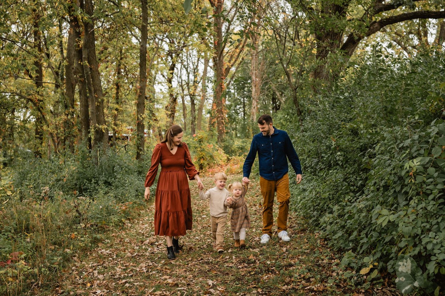 A family of four holding hands and walking