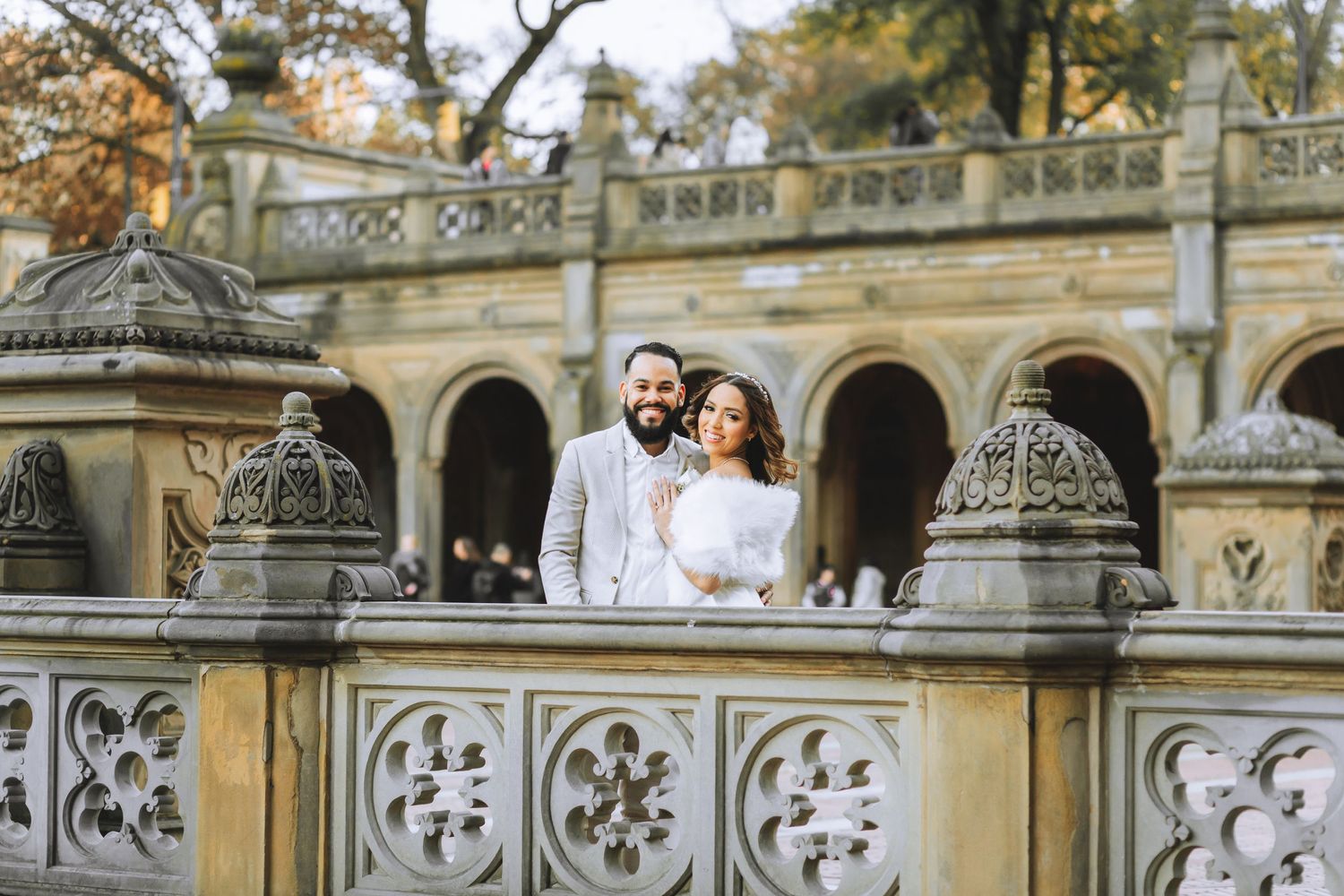 A romantic couple portrait at an ornate stone balcony with architectural details.