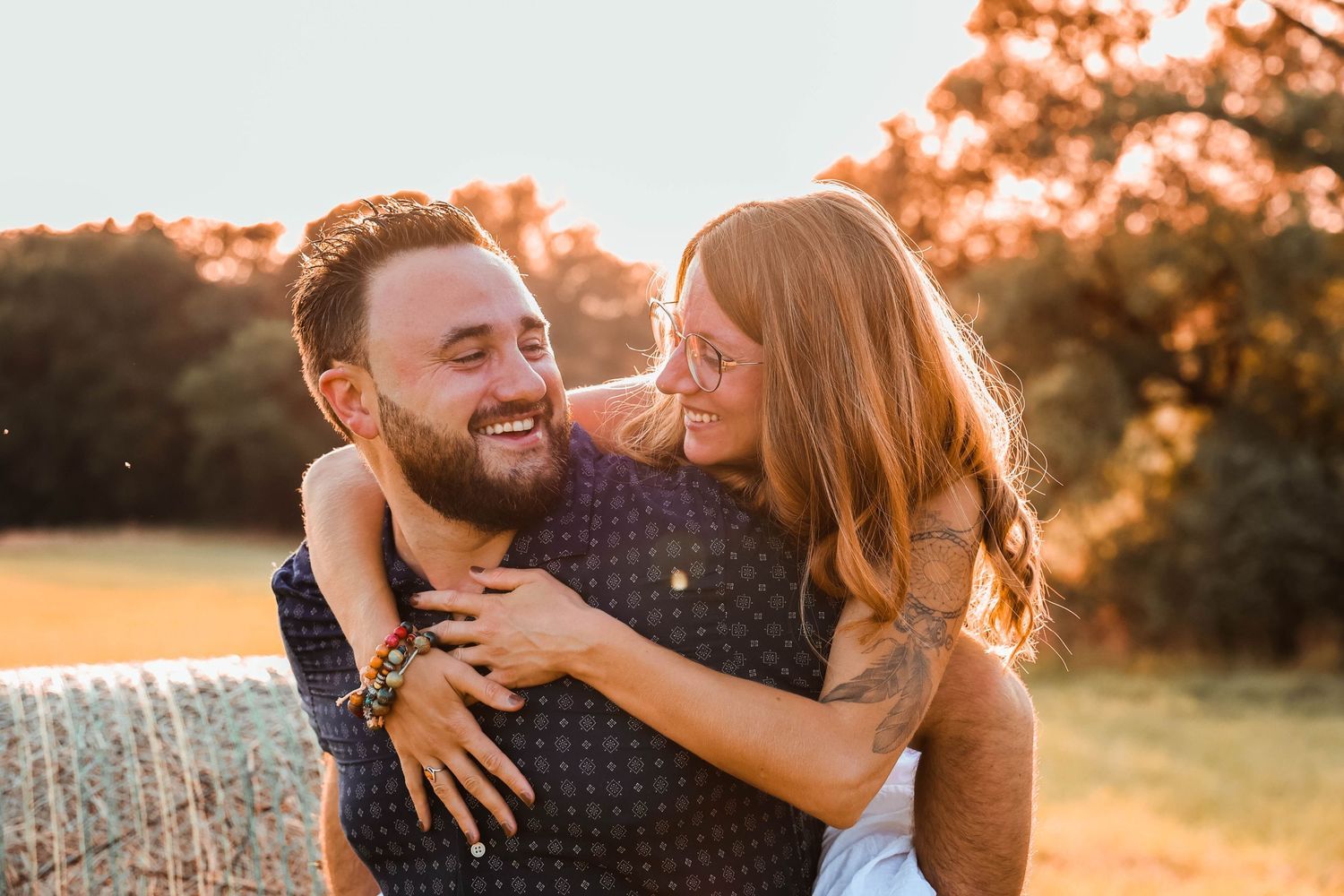 Romantic sunset portrait capturing joyful embrace in golden hour light.