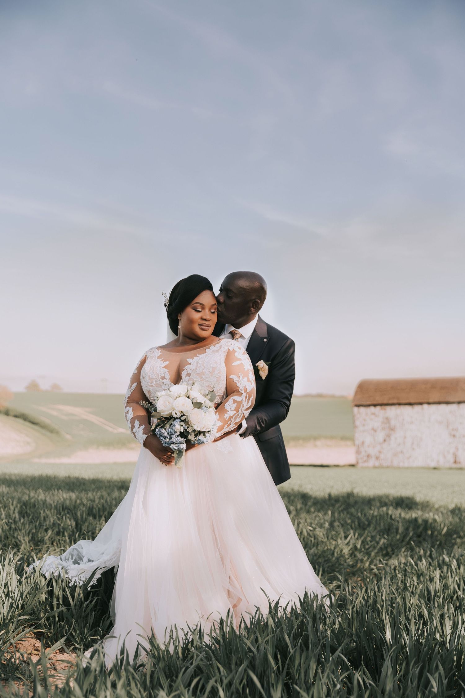 Romantic wedding photos in flowing white dress against green countryside.