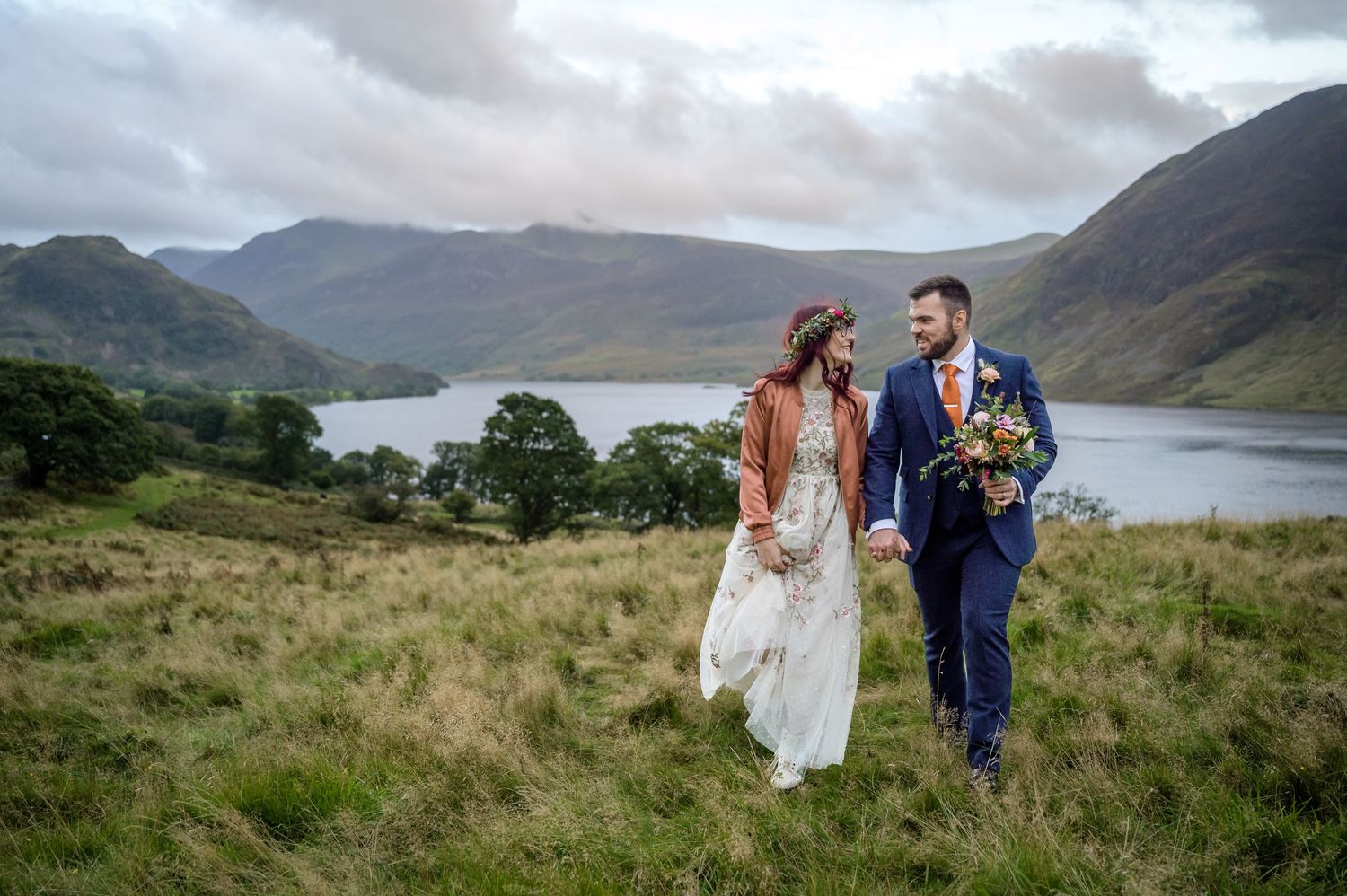 Bride and groom in field overlooking Crummock Water