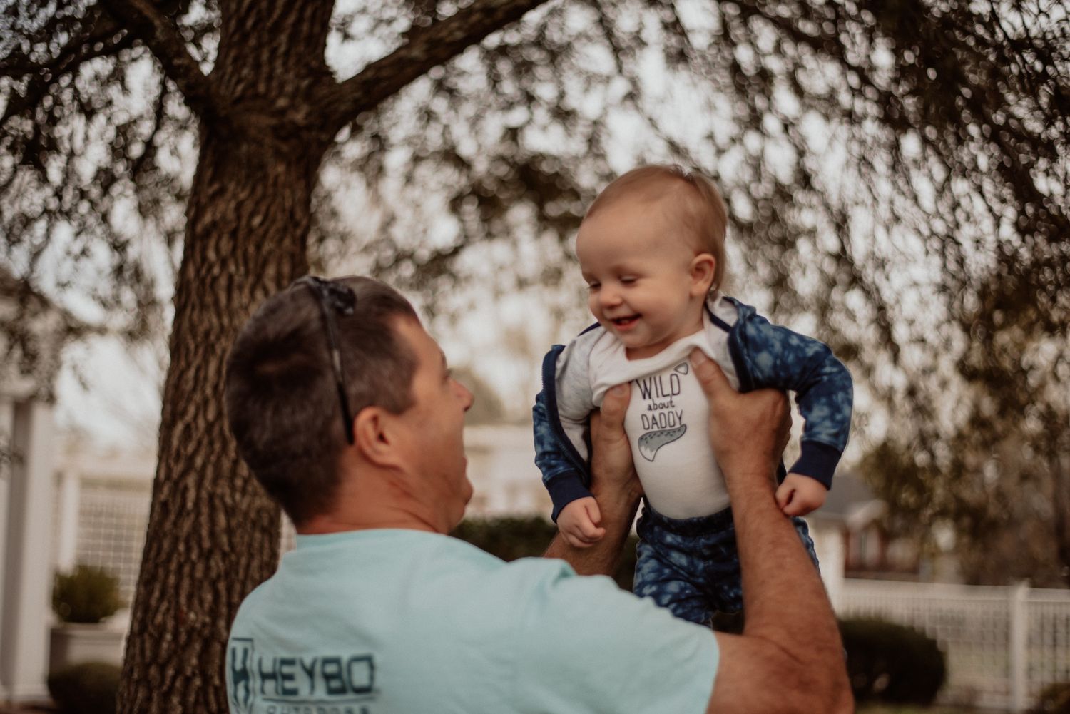 A grandpa holds his young granddaughter in the gardens at the Leak-Wall House in Rockingham, NC during a session with Miranda Jo Photography