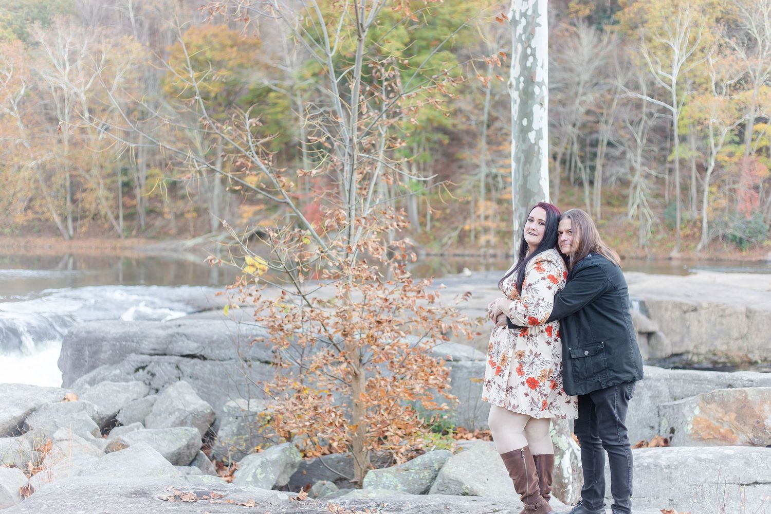 Outdoor engagement photo session in a wooded area during autumn.