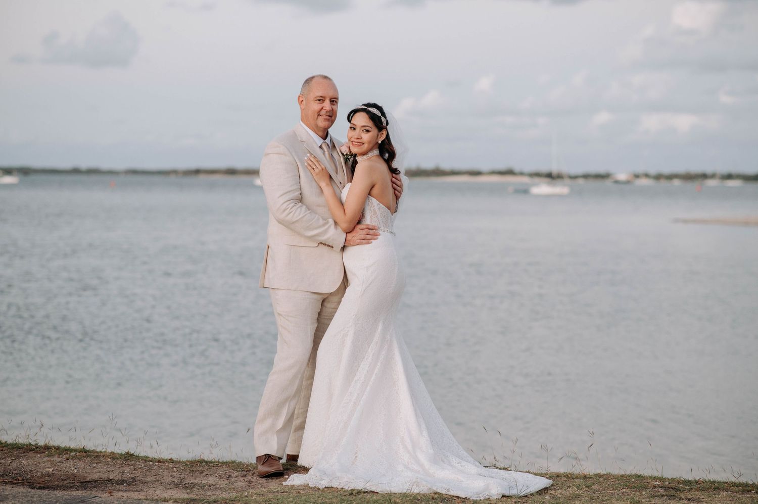 Beachside wedding portrait with ocean backdrop during golden hour.