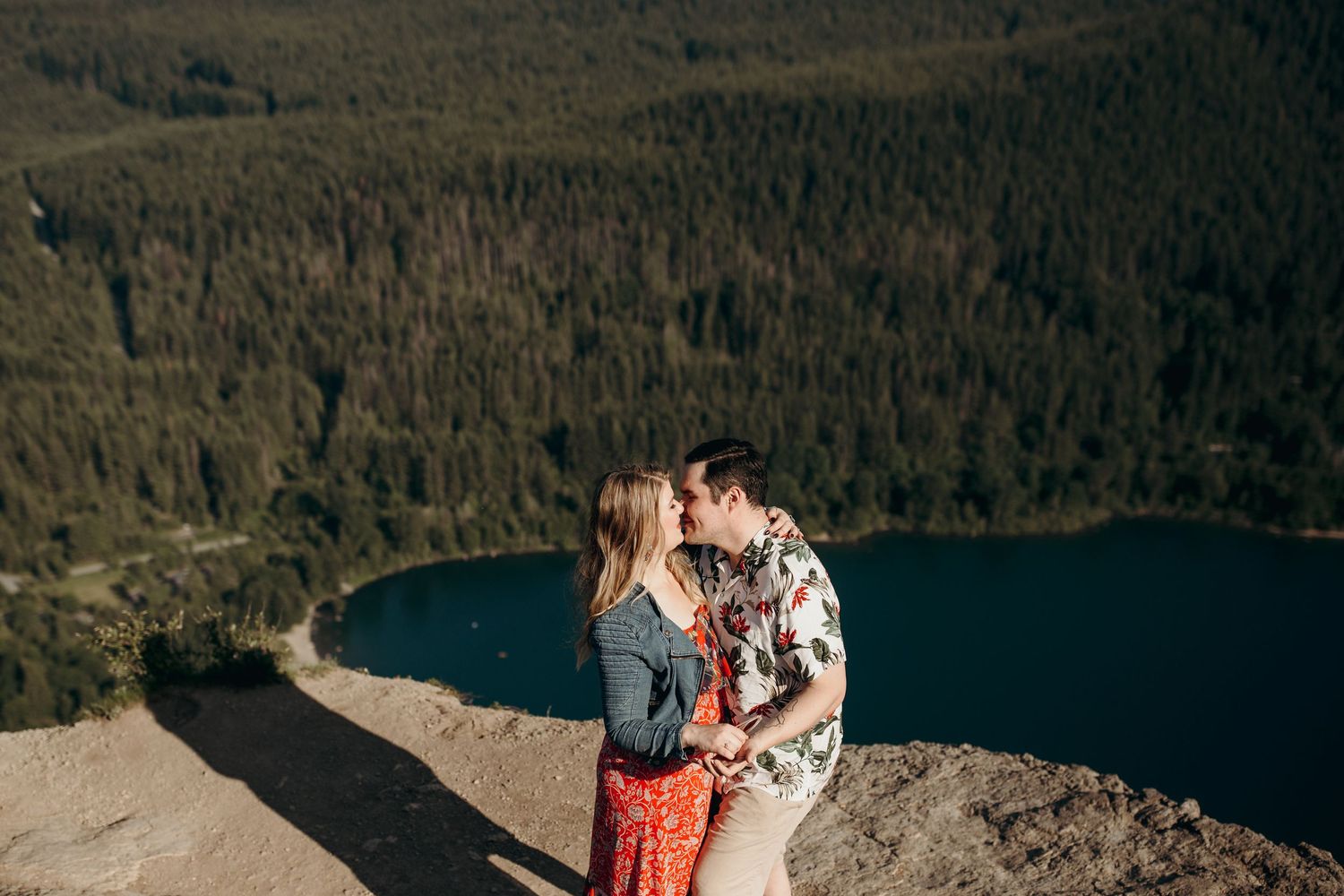 Photos from a Rattlesnake Ledge engagement session of a couple embraced and overlooking Rattlesnake Lake.