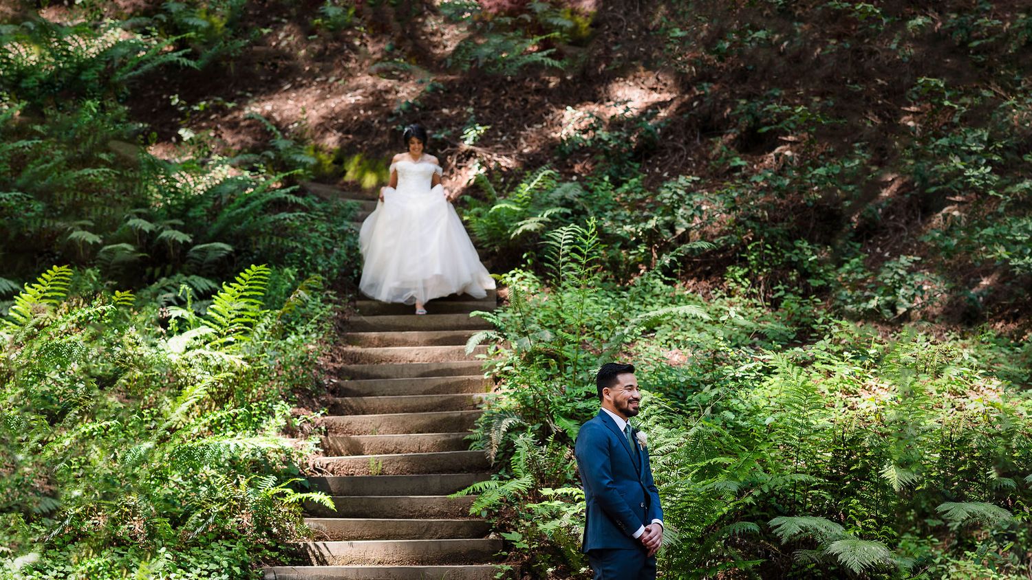 Wedding couple sharing a private first look moment on forest steps.