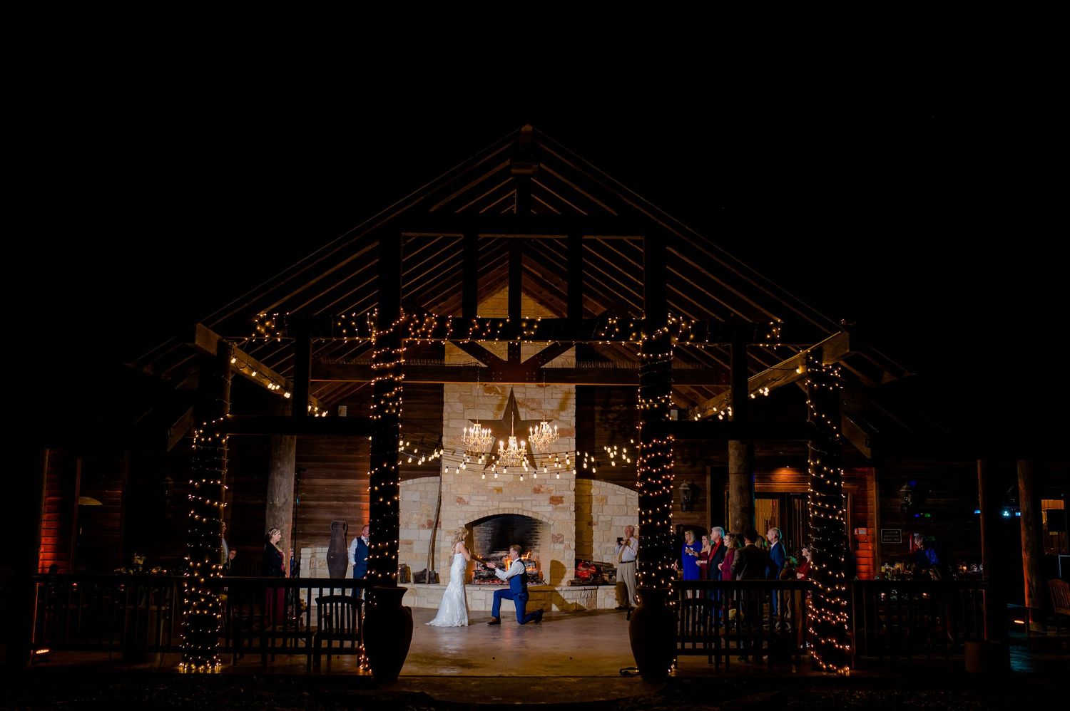 Nighttime exterior shot of a rustic wedding venue with dramatic lighting and star decor.