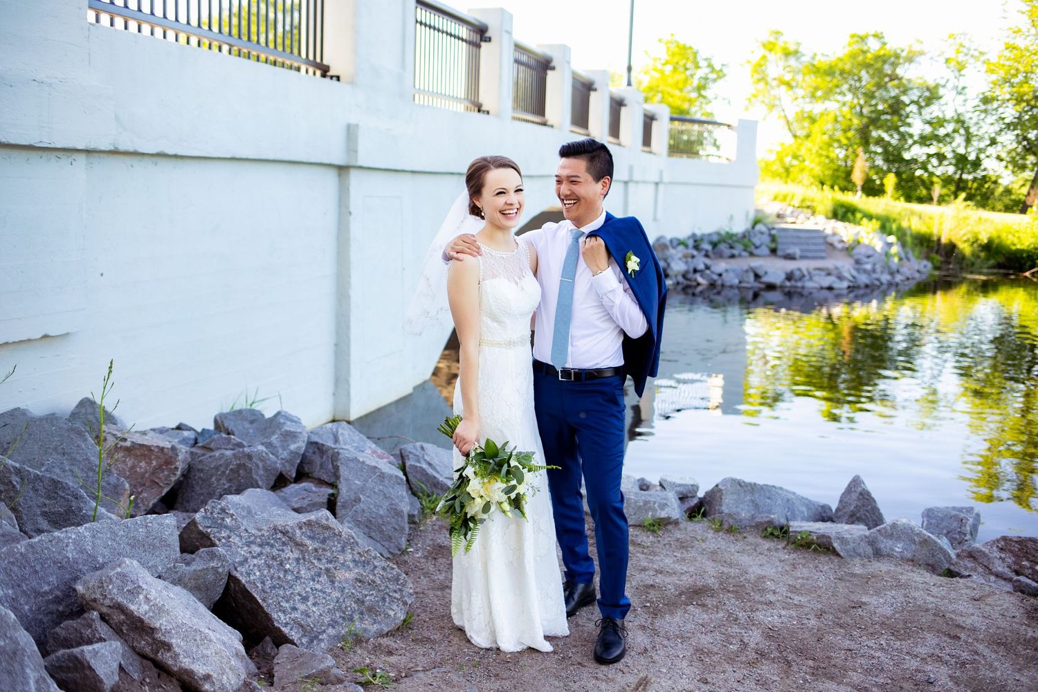 Bride and groom laughing in front of bridge, intimate Minnesota backyard wedding, Laura Leigh Images