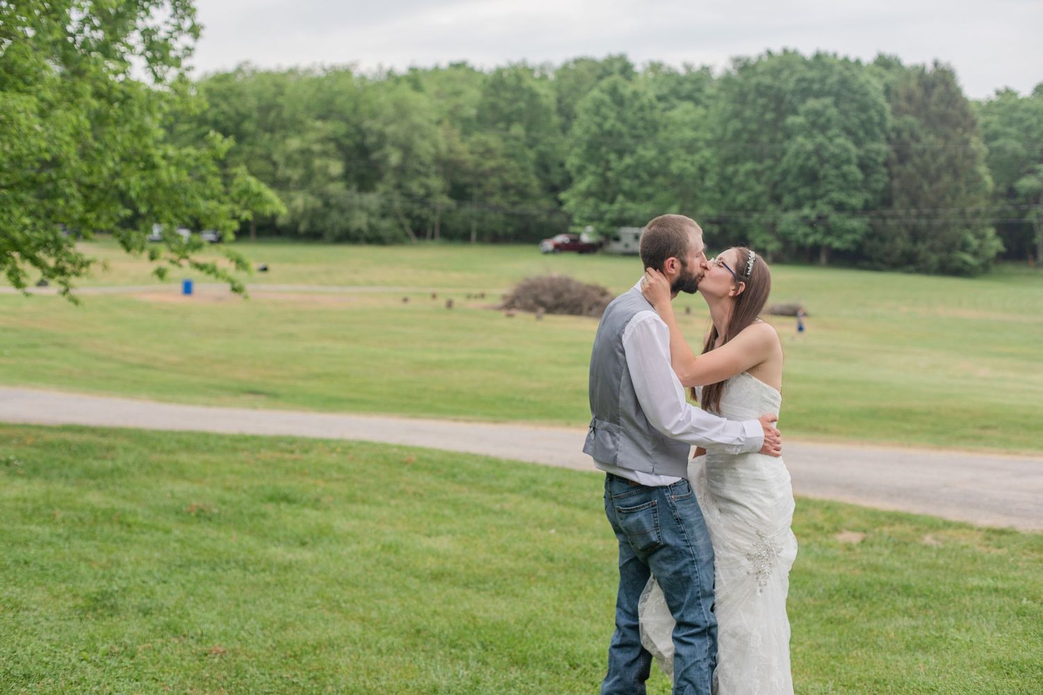A romantic wedding photoshoot in a lush green outdoor setting with white floral bouquets.