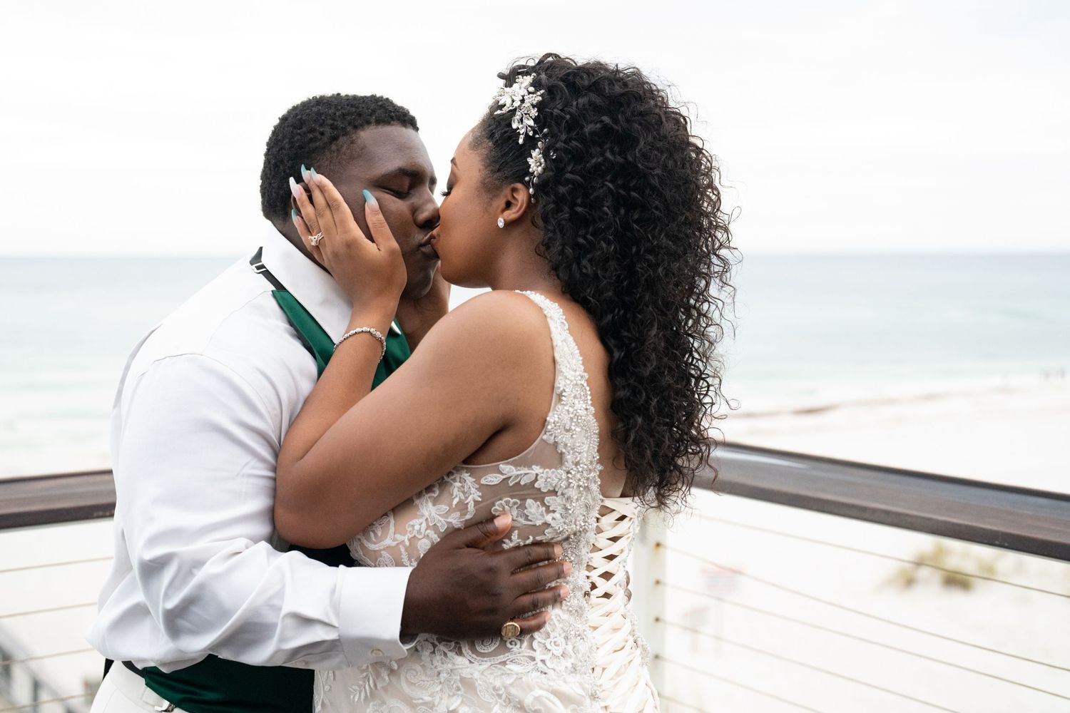 A romantic beachside moment between newlyweds with ocean in background.
