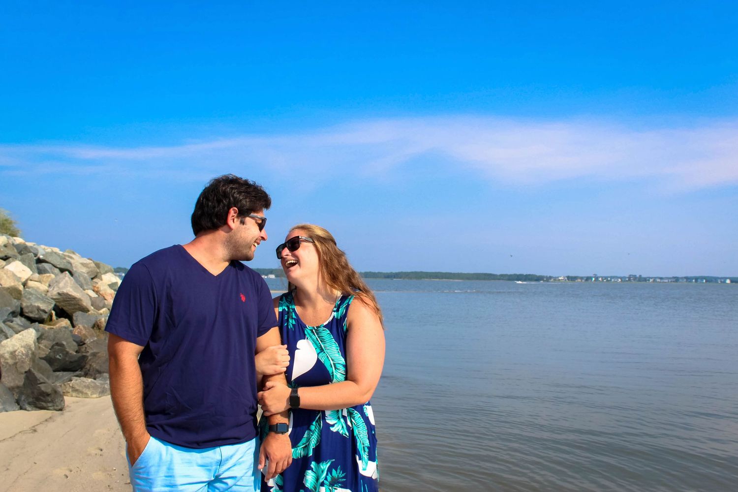 Happy couple sharing tender moment at sunny beach overlook.