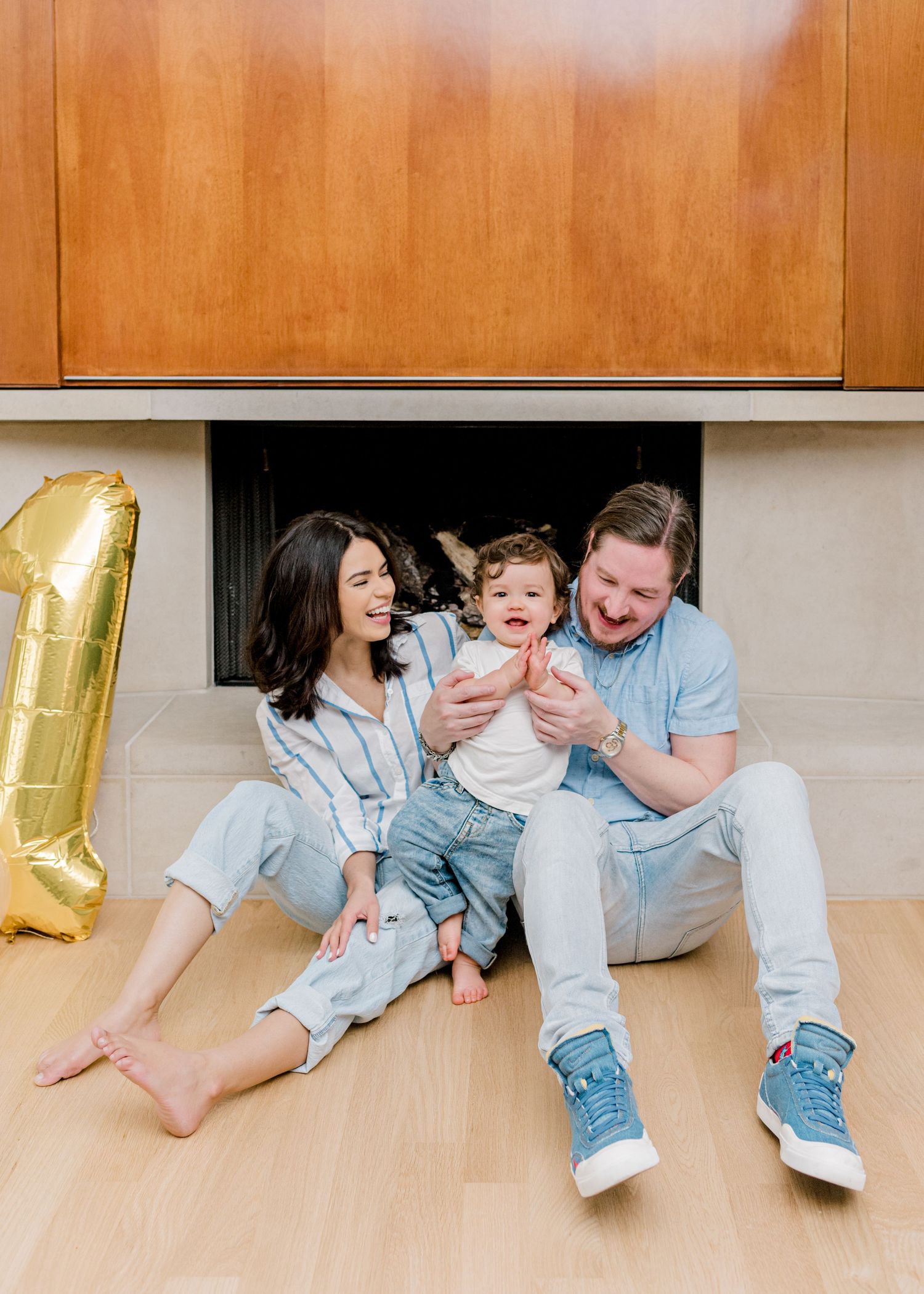 mom and dad laughing with baby boy as he claps his hands