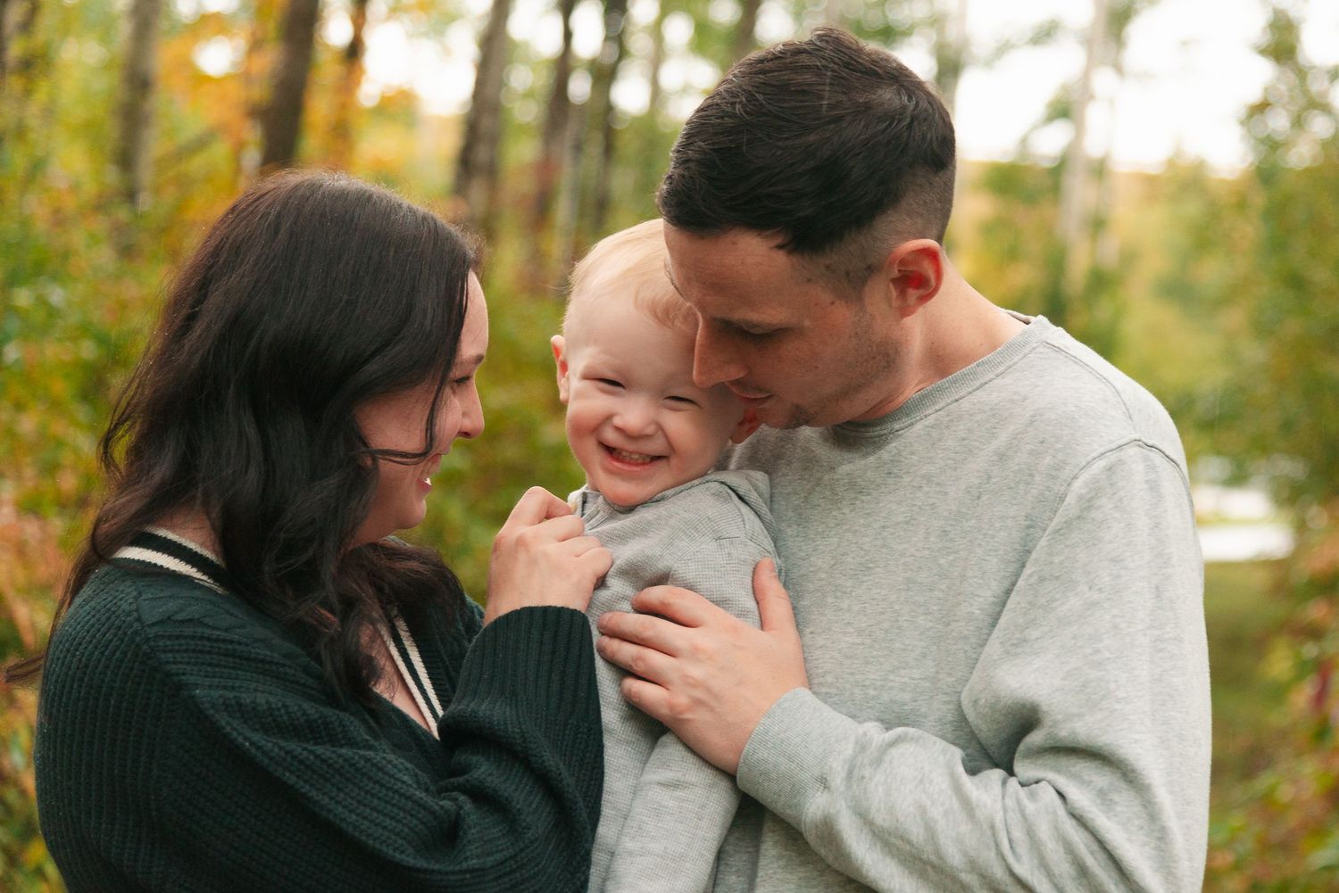 A close intimate family moment captured against an autumn forest backdrop.