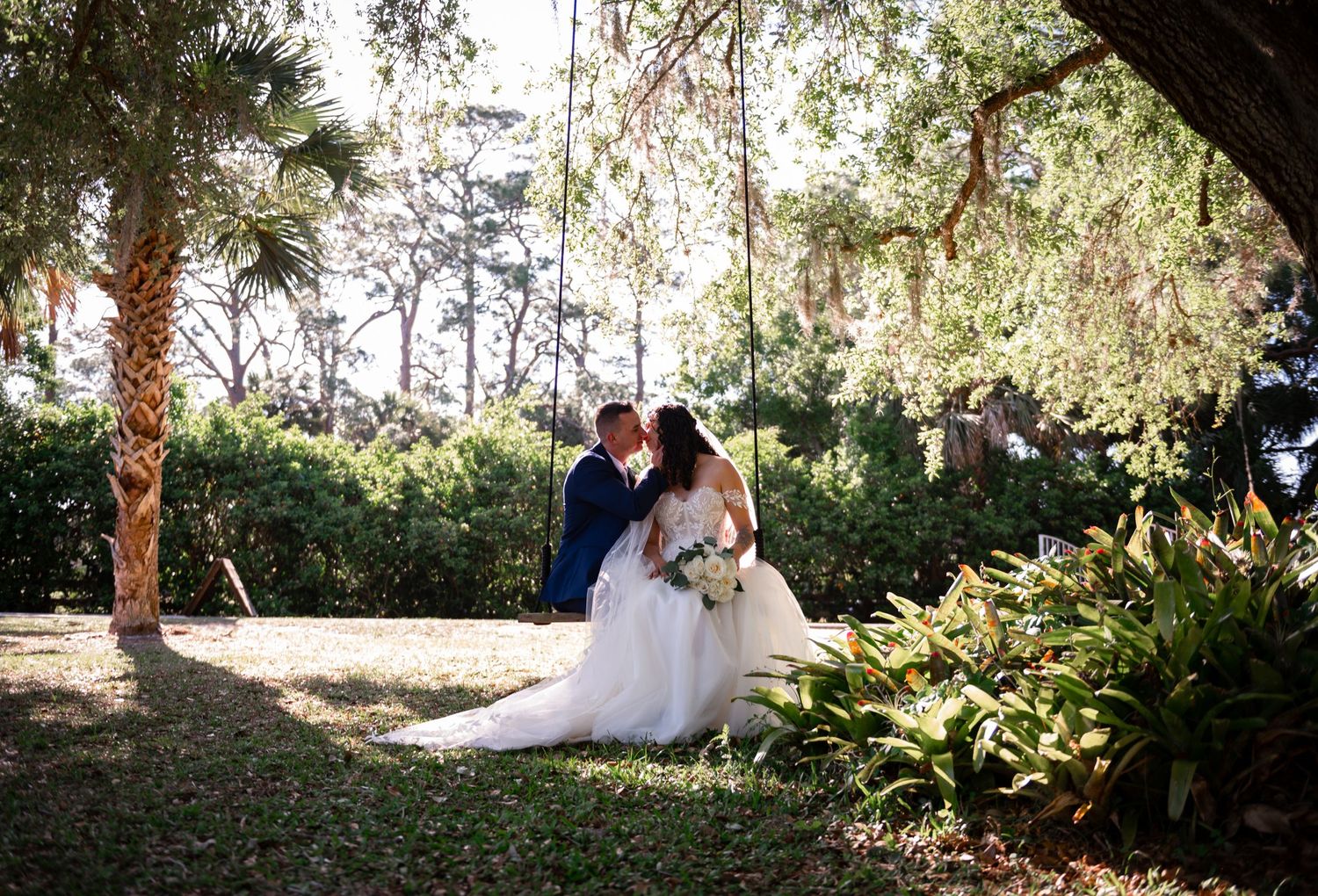 A couple is seated on a garden swing at sunset in South Florida, wrapped in warm light and quiet intimacy. South Florida wedding photography