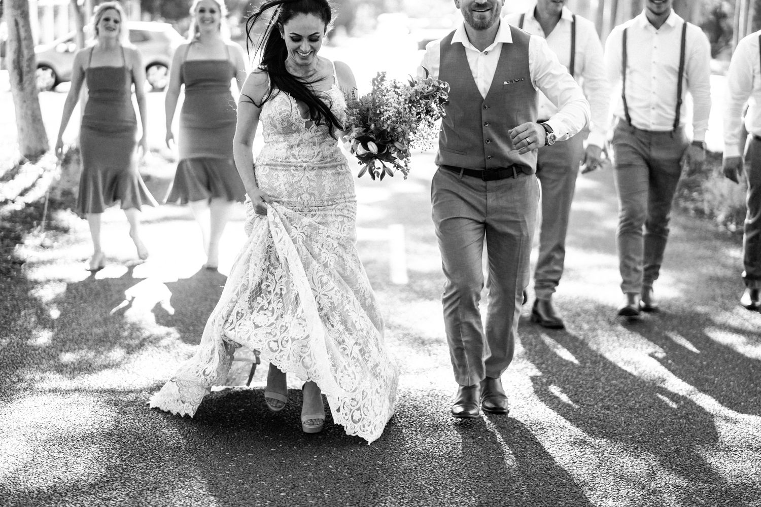 Black and white photo of couples dancing outdoors at a wedding celebration.