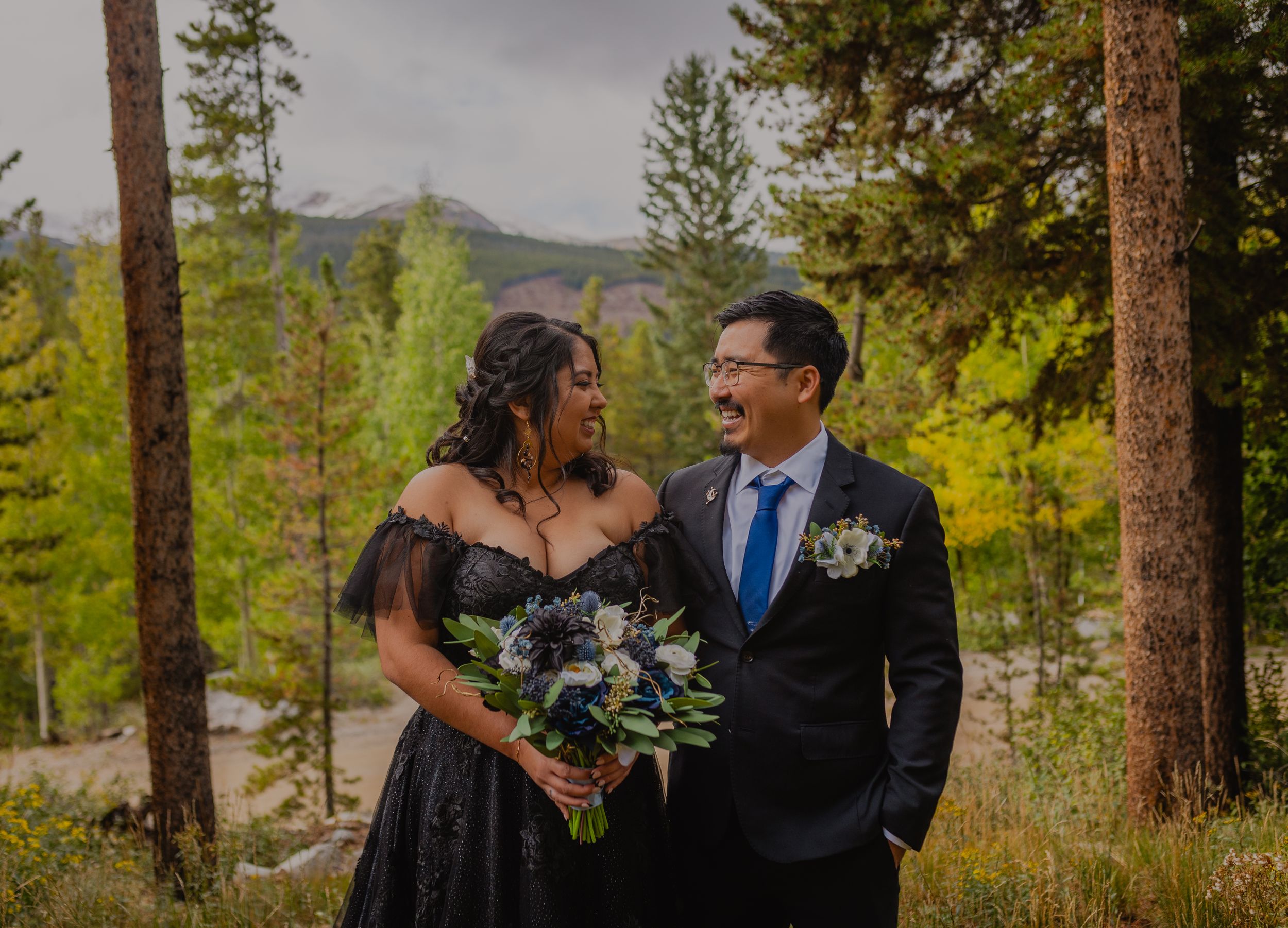 Close-up of bride’s lace dress with mountains in the background, emphasizing the elegance of a Breckenridge elopement