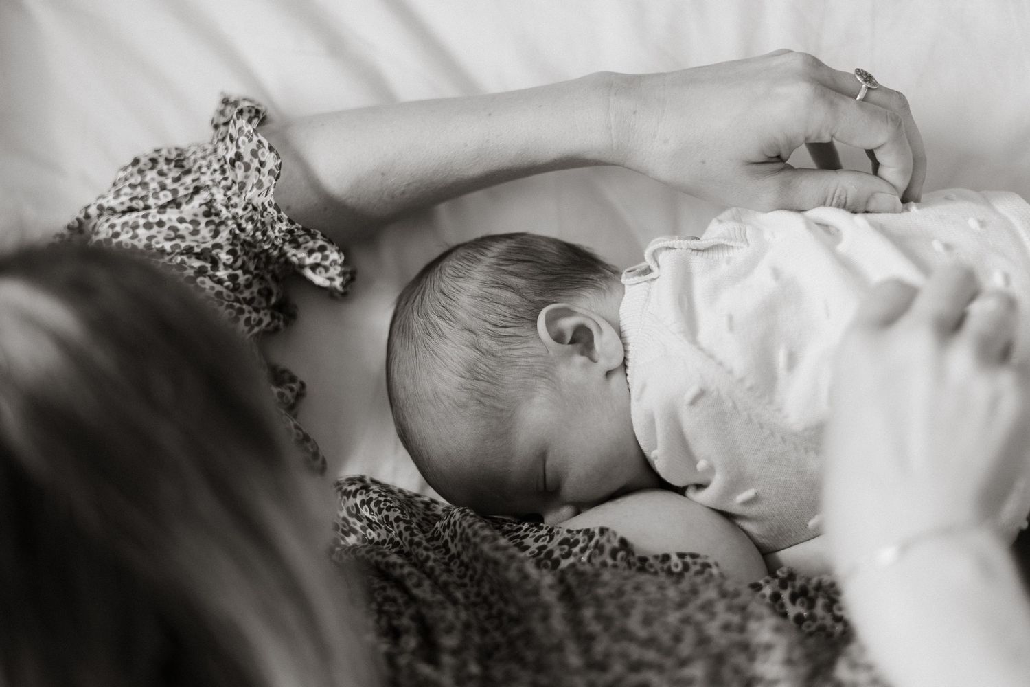 A mum breastfeeds her newborn in a side-lying position