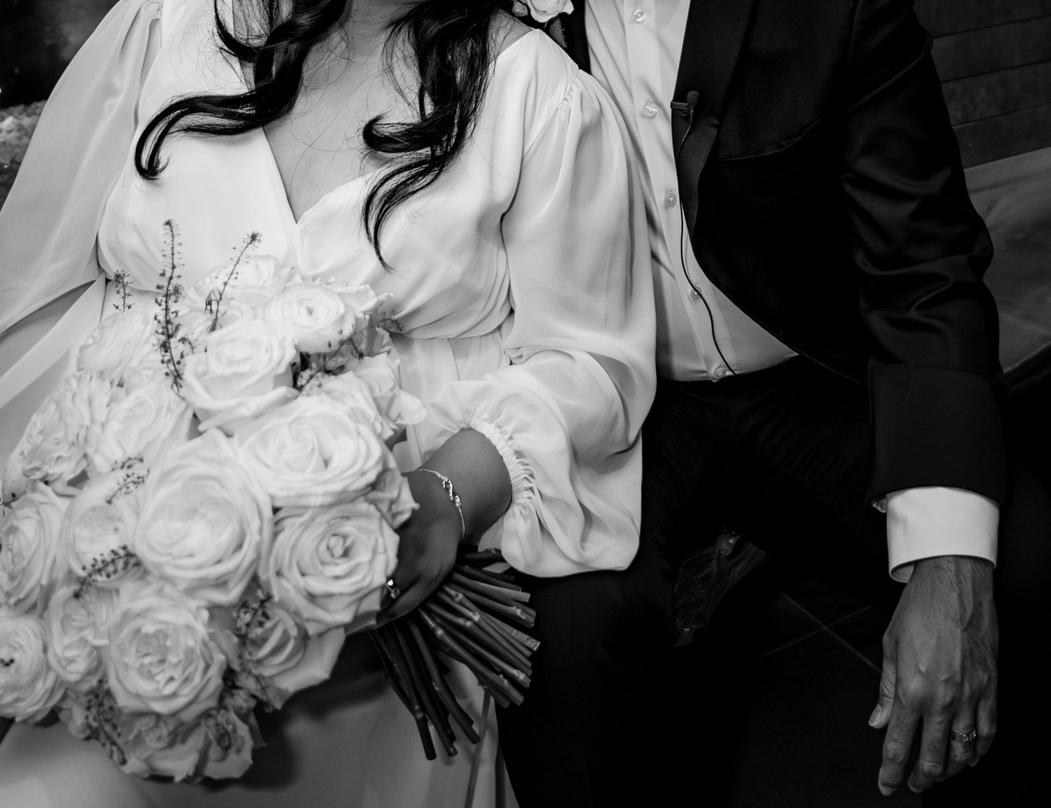 Close up detail of white rose wedding bouquet with delicate lace accents.