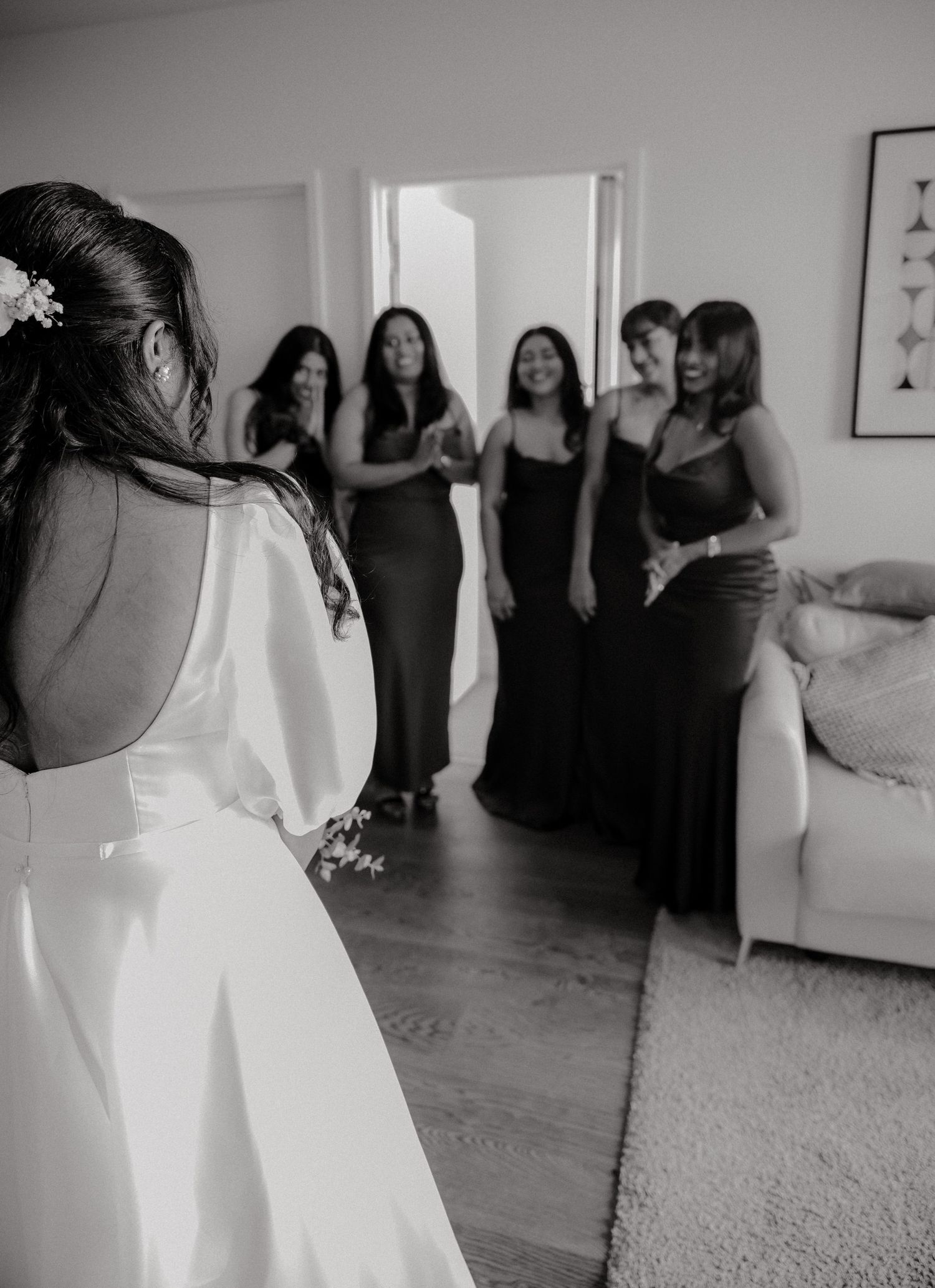 A sequence of black and white photos showing people celebrating at a dance event in a white, bright room.