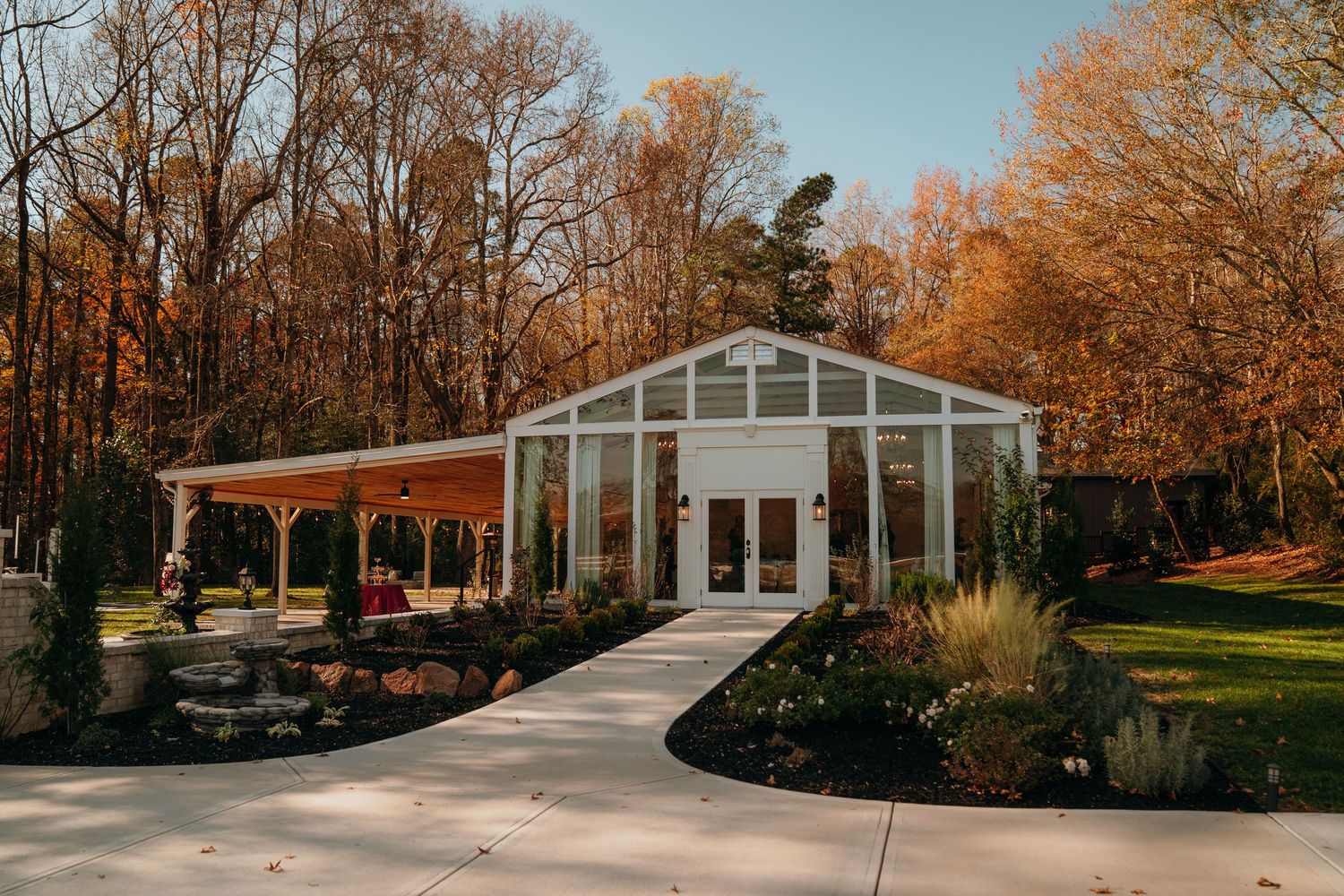 A panoramic autumn landscape shows a series of connected garden scenes with trees displaying golden fall foliage.