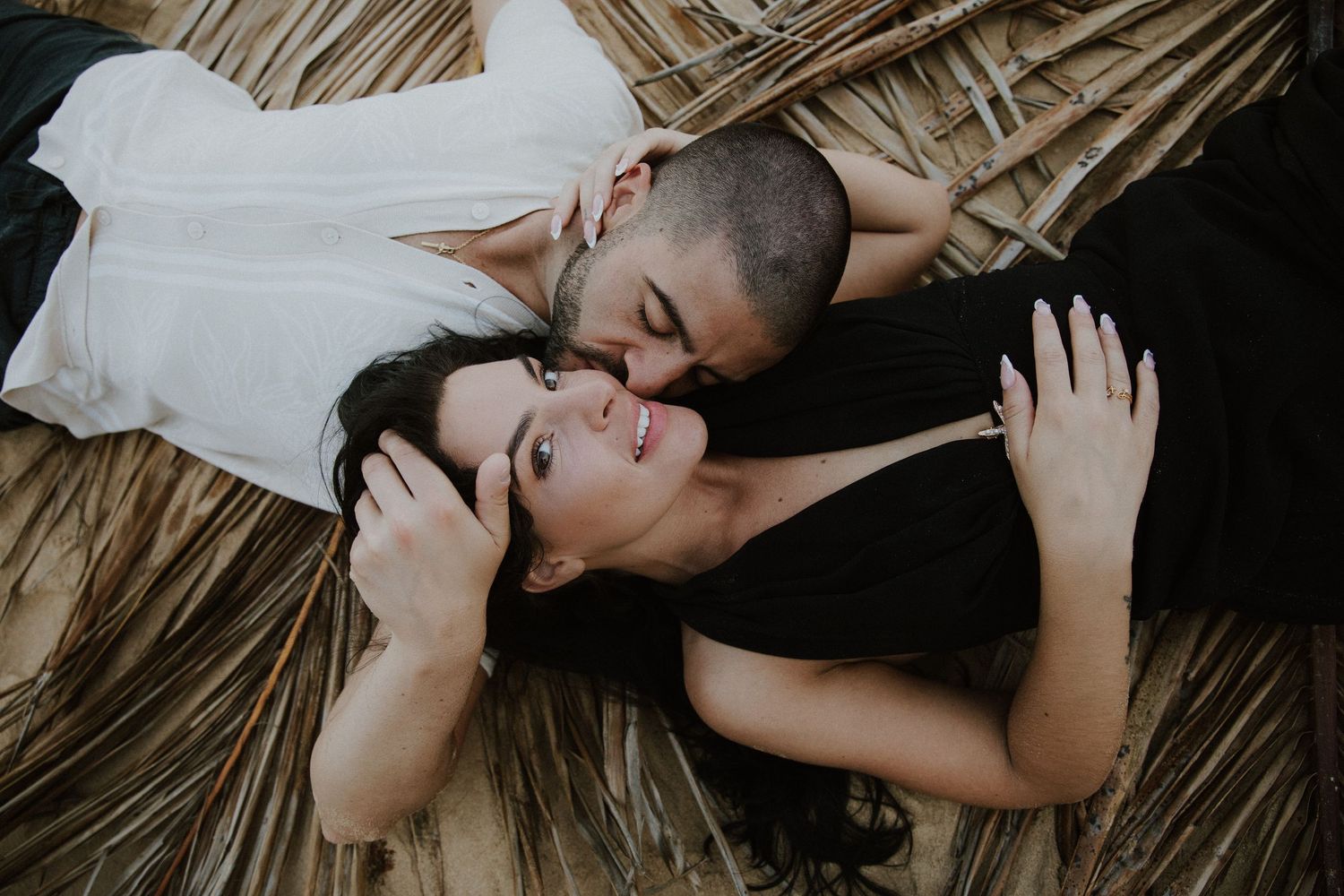 A tender beachside embrace captured against an ocean backdrop.