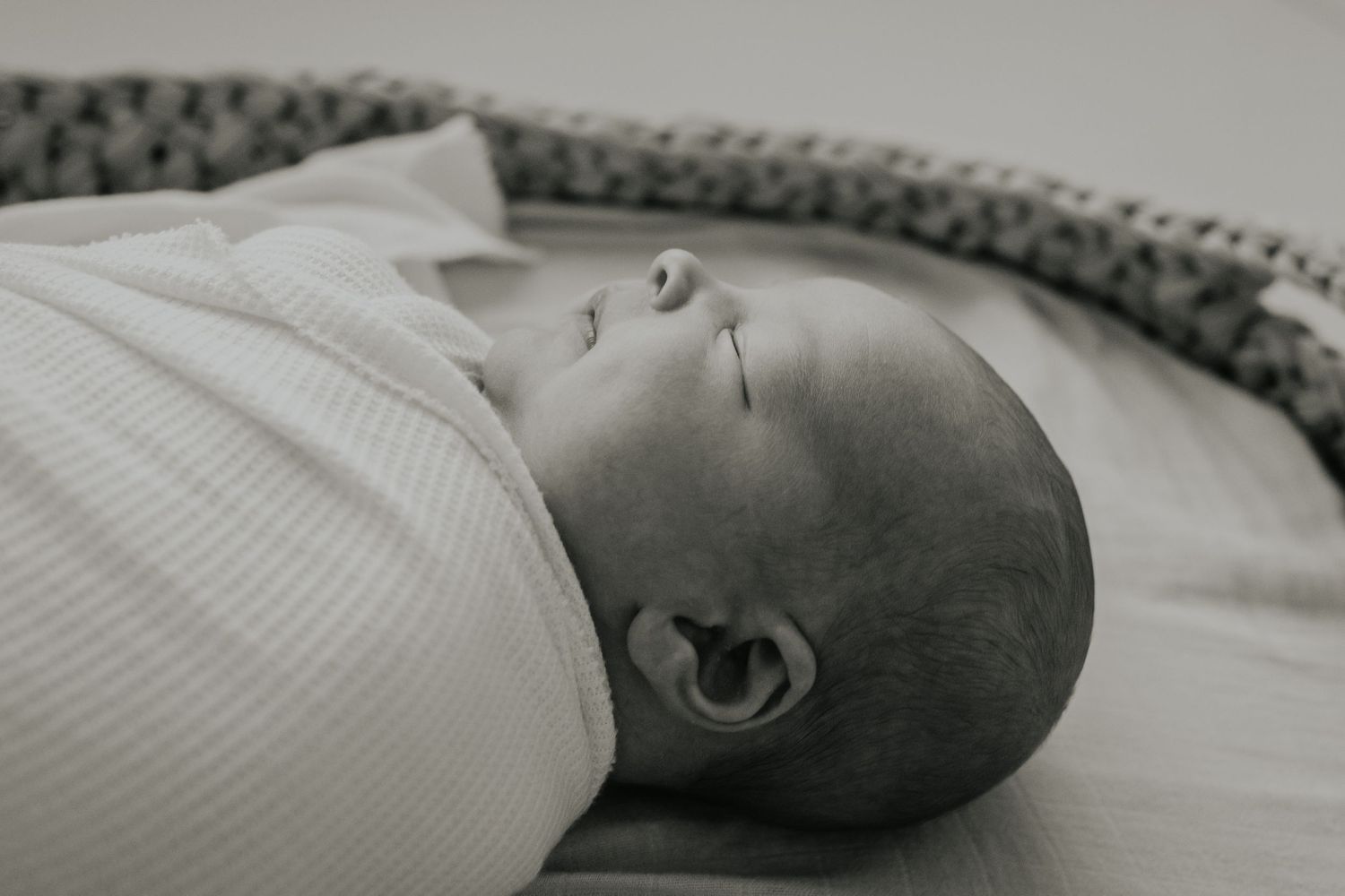 Black and white photo sequence showing different shots of a sleeping baby lying in a striped bed.