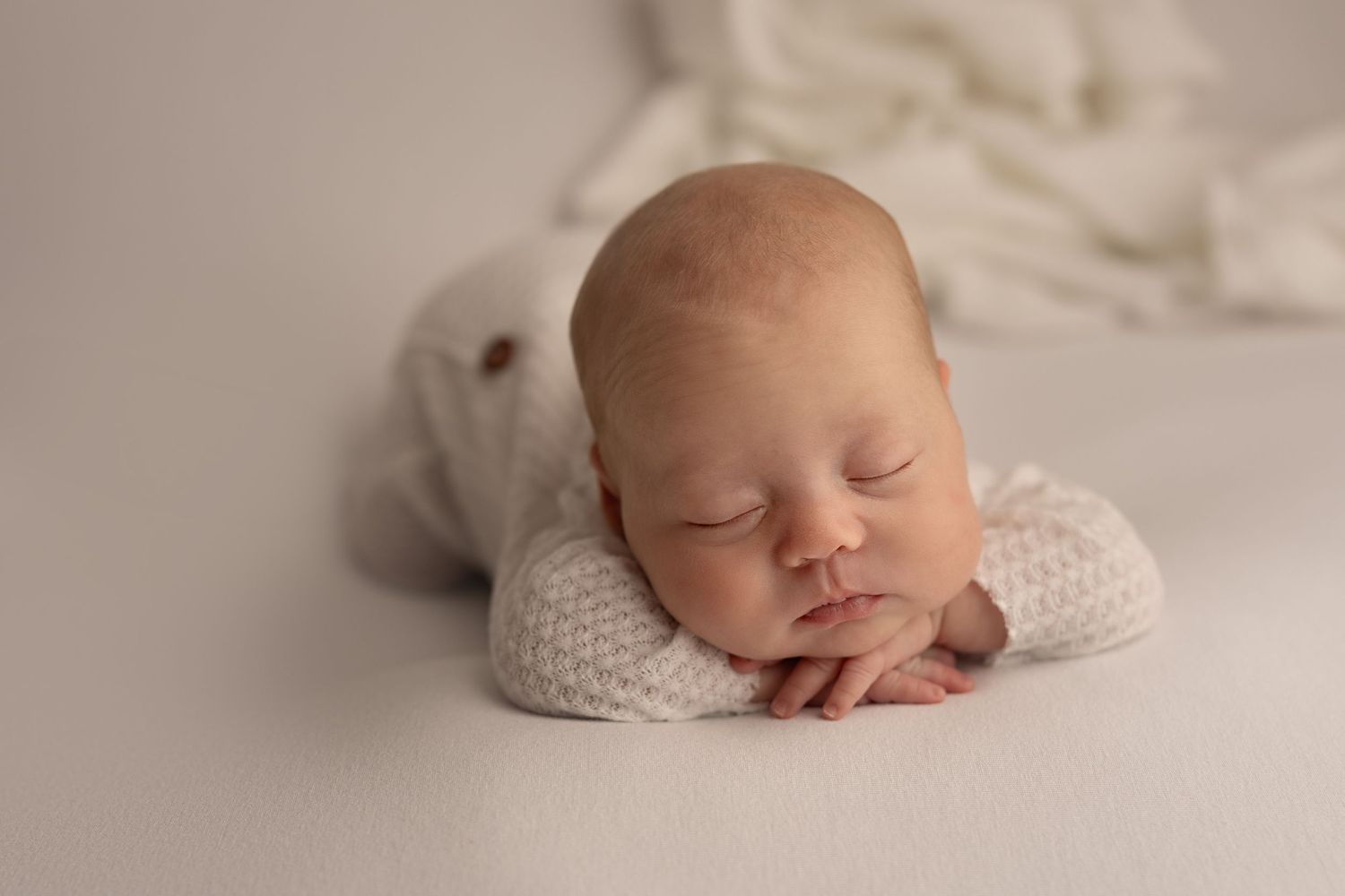 Artistic newborn photography series showing peaceful sleeping poses on light neutral background.